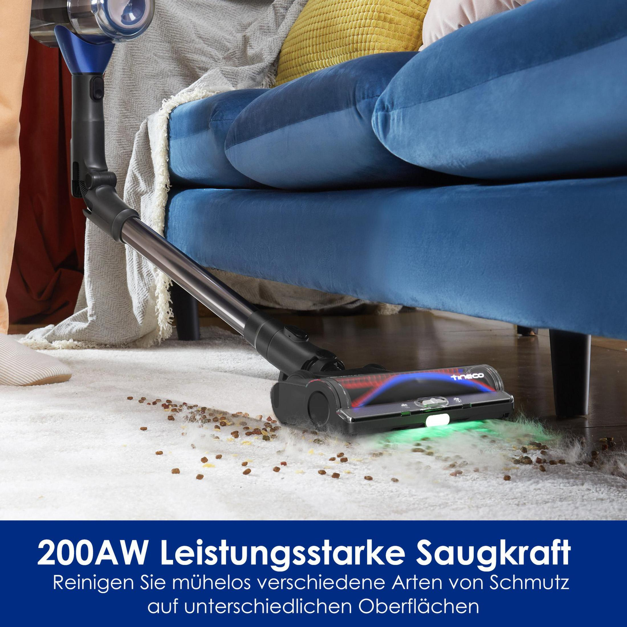 Ein blauer Staubsauger reinigt einen weißen Teppich mit Schmutzpartikeln.