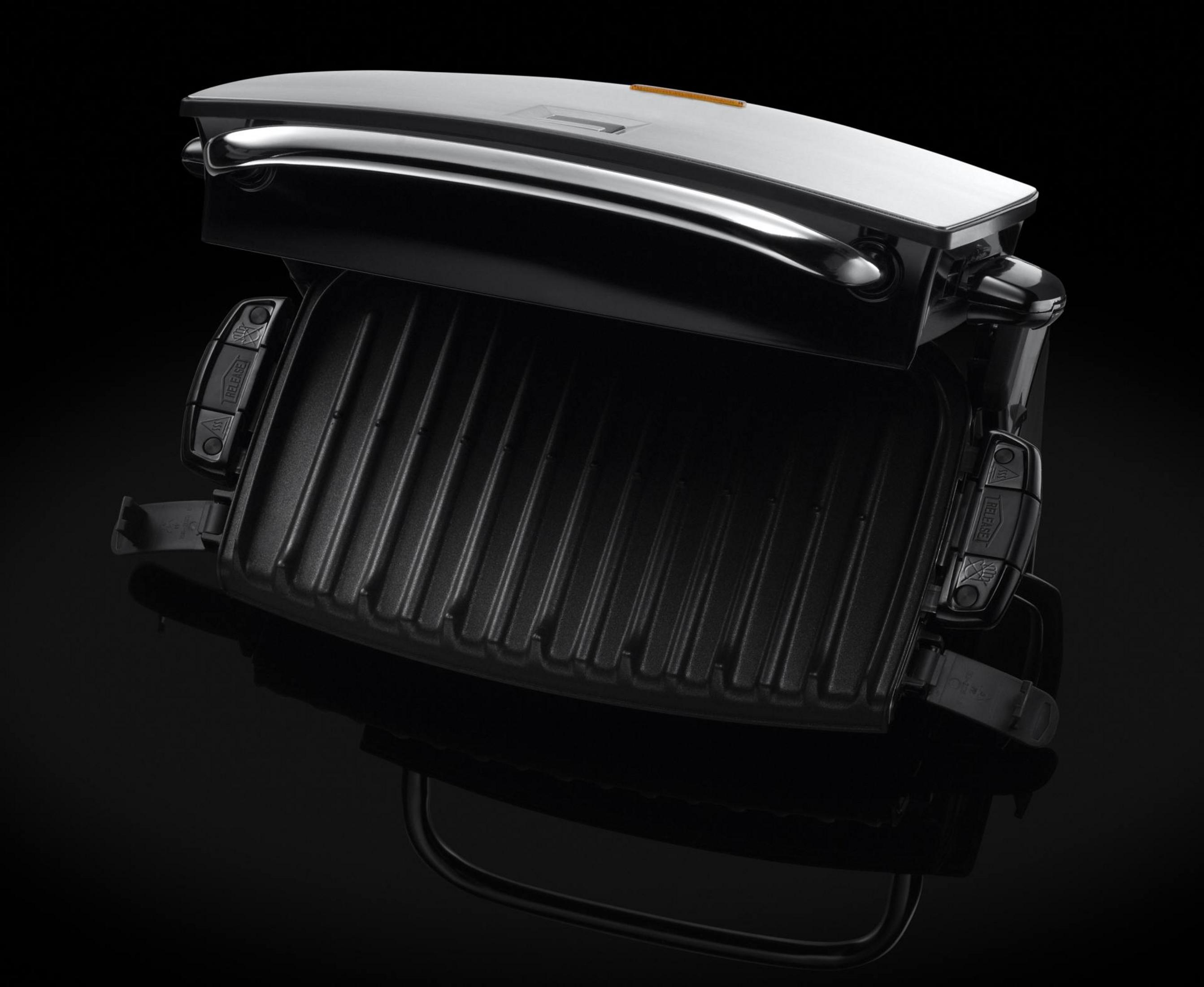 Ein offener, schwarzer Kontaktgrill mit gerillten Grillplatten und silbernem Griff.