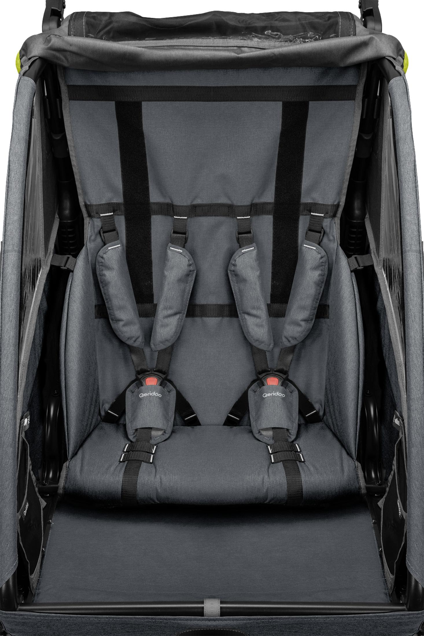 Grauer Kinderwagen-Innenraum mit Gurten und Sitzpolsterung.