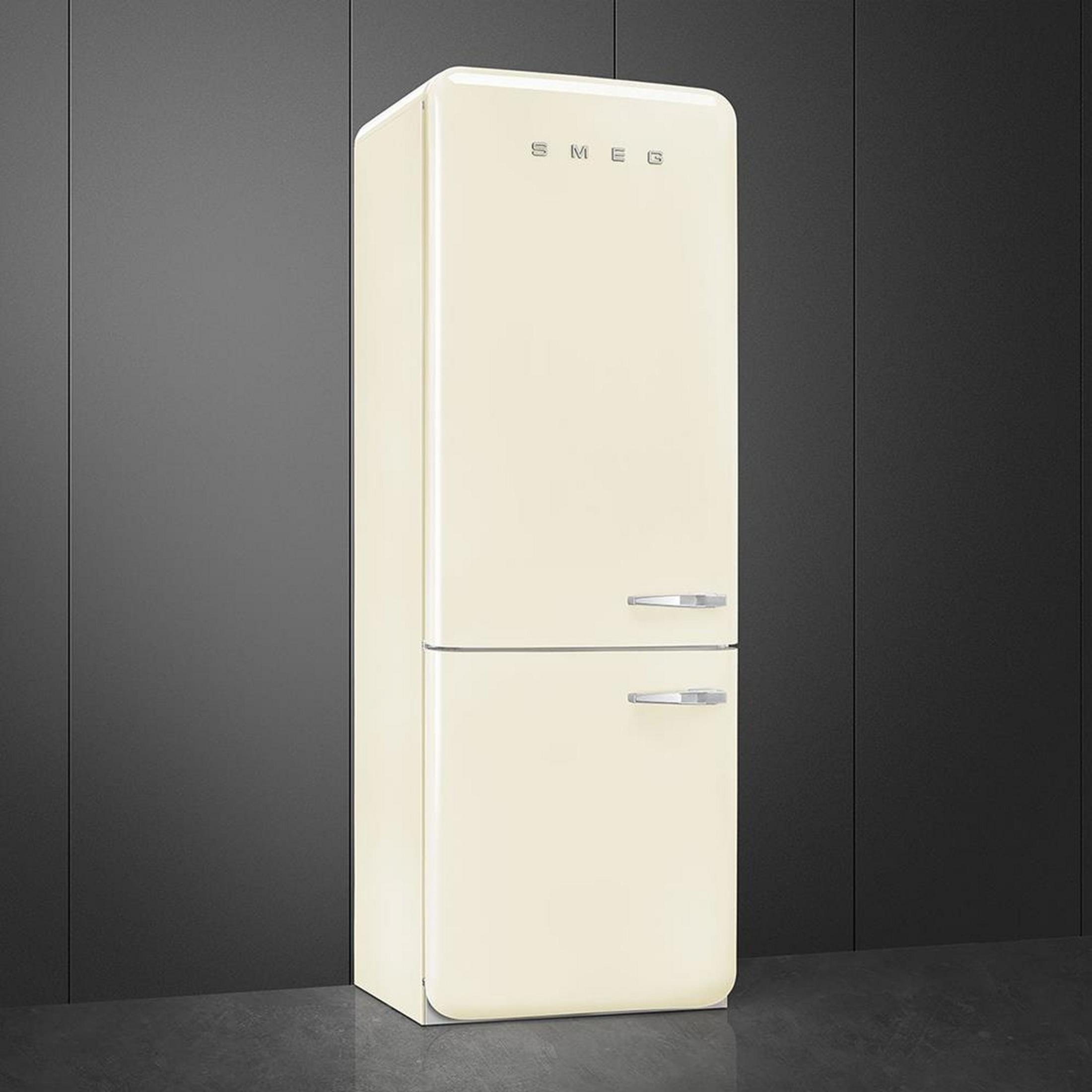 Un refrigerador color crema con tiradores plateados frente a una pared oscura.