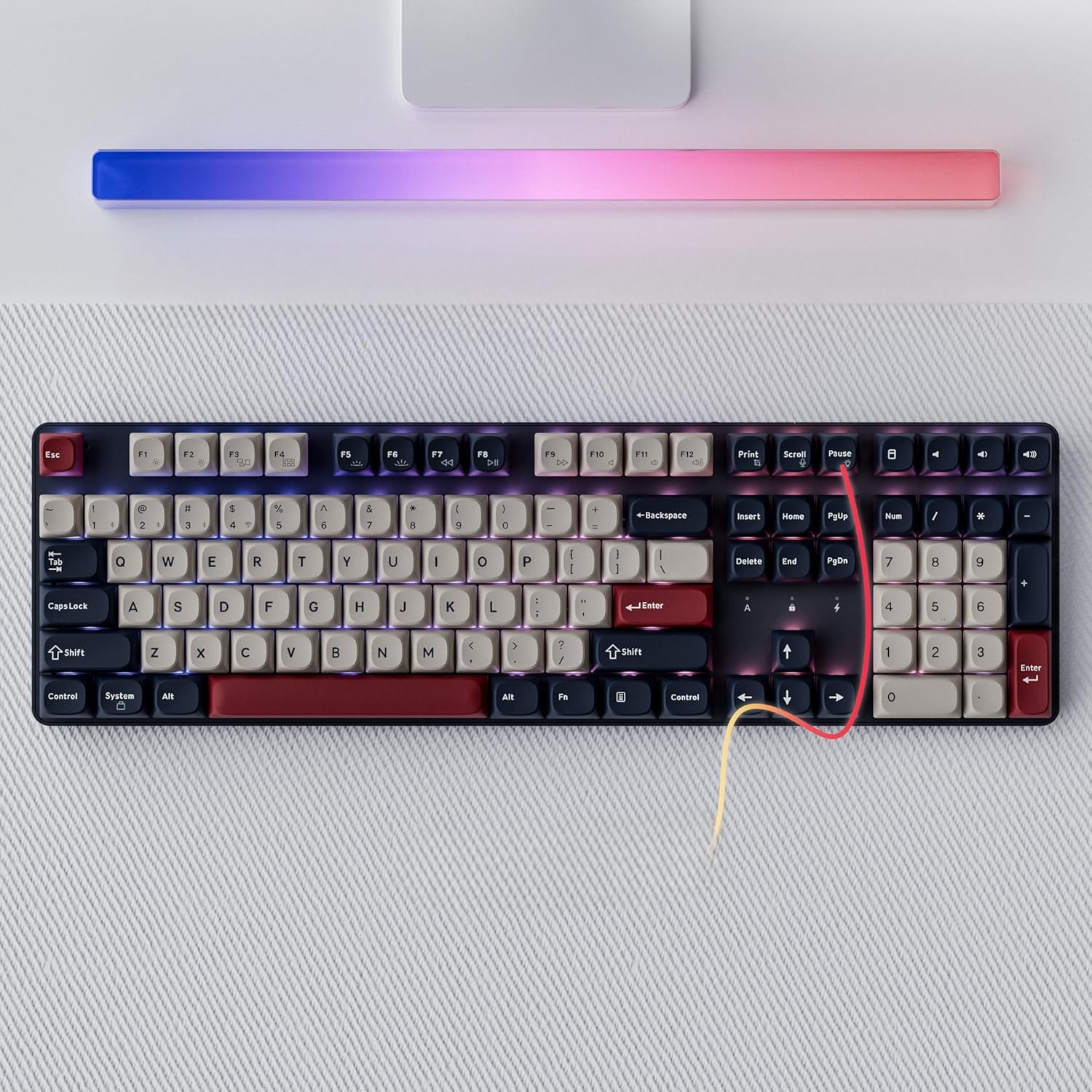 Czarna klawiatura z kremowymi i czerwonymi klawiszami, oświetlona listwą świetlną RGB.