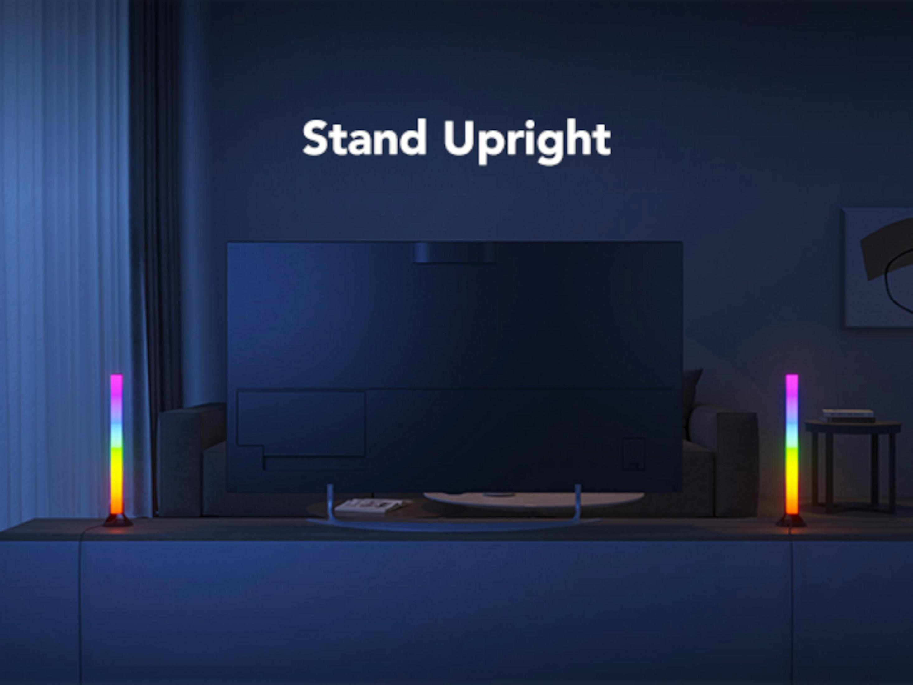 Een tv staat op een kast met regenbooglampen aan weerszijden.