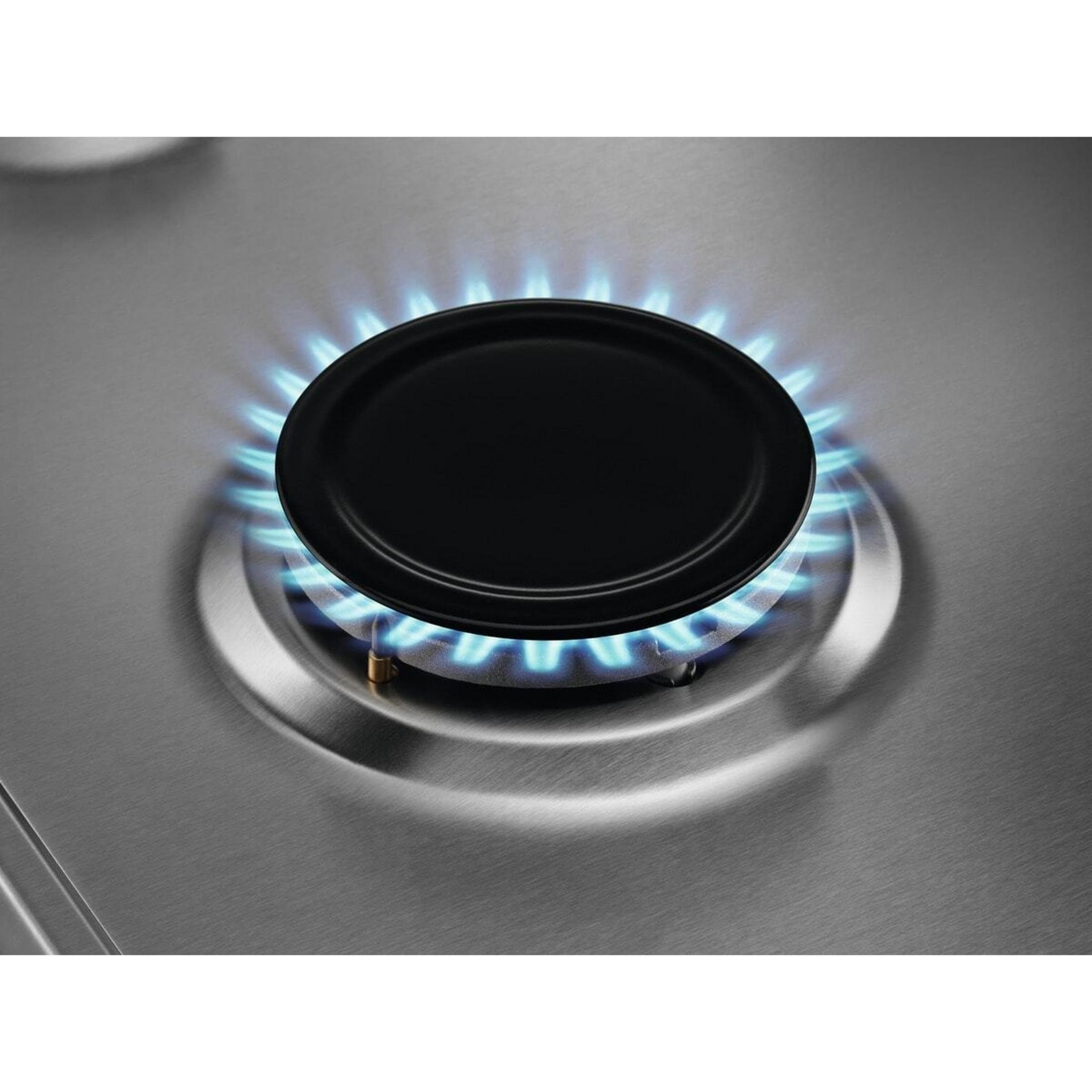 Una pentola nera su un fornello a gas con fiamma blu.
