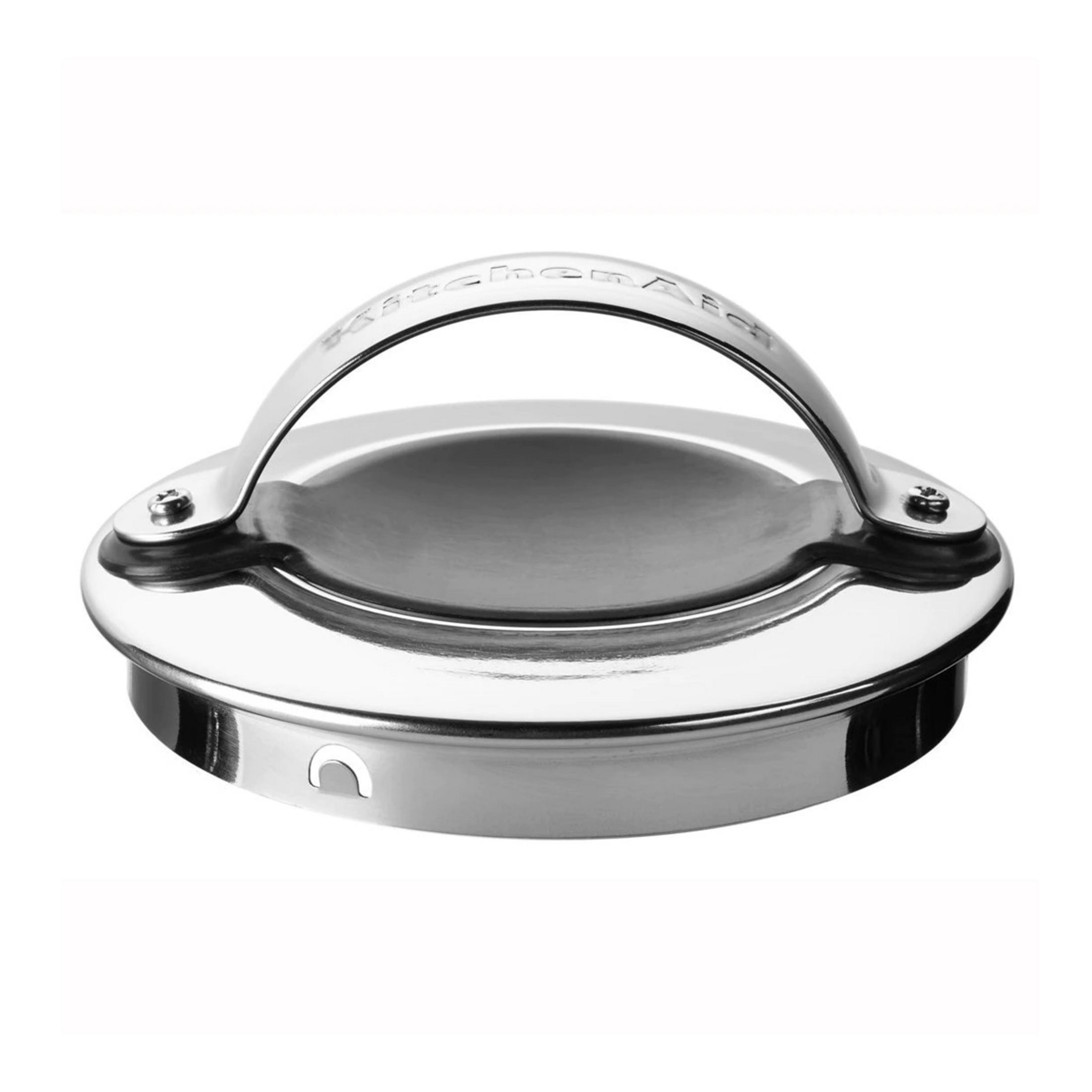 Coperchio in metallo lucido con manico curvo e viti. Logo KitchenAid visibile.
