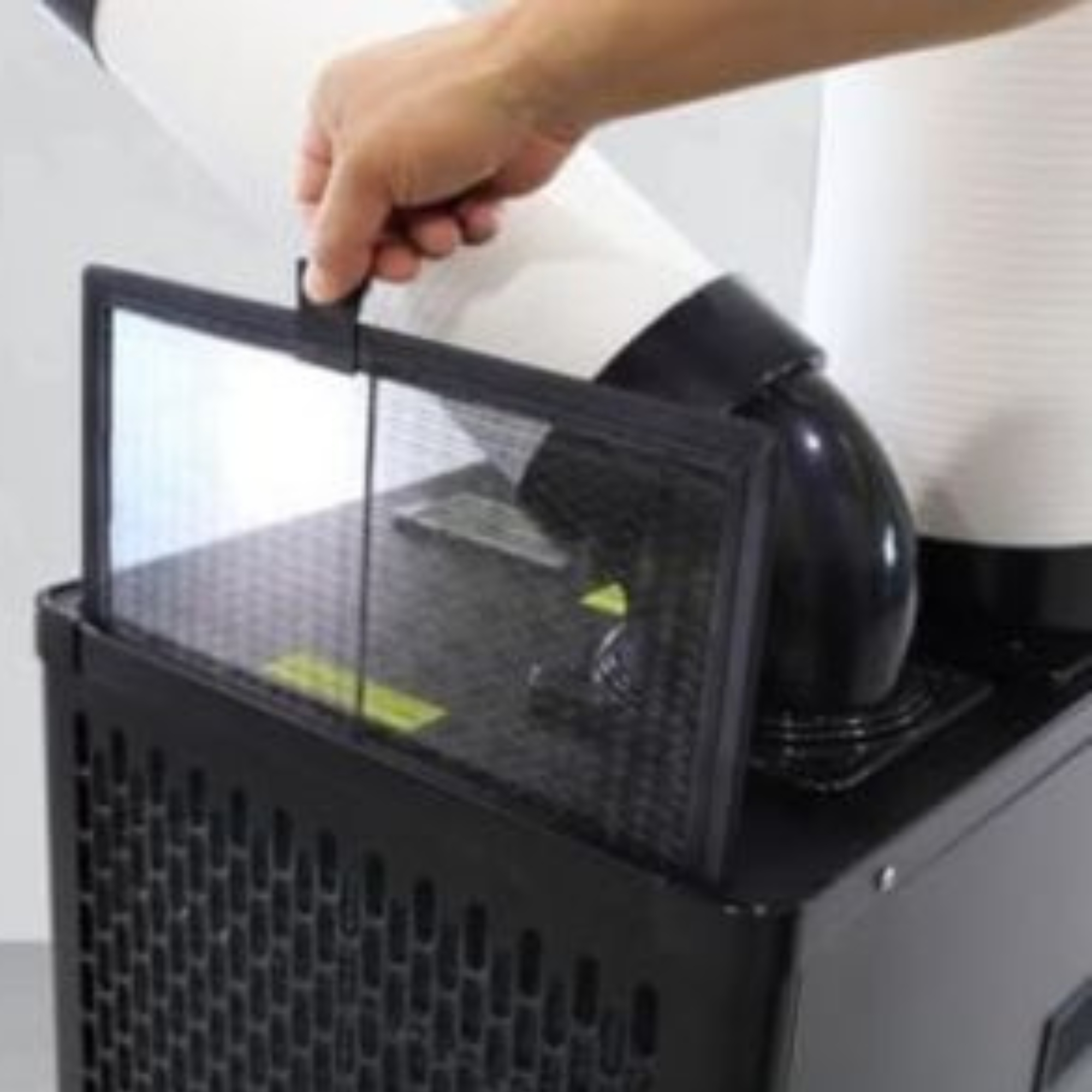 Una mano saca un filtro negro de una ventilación.