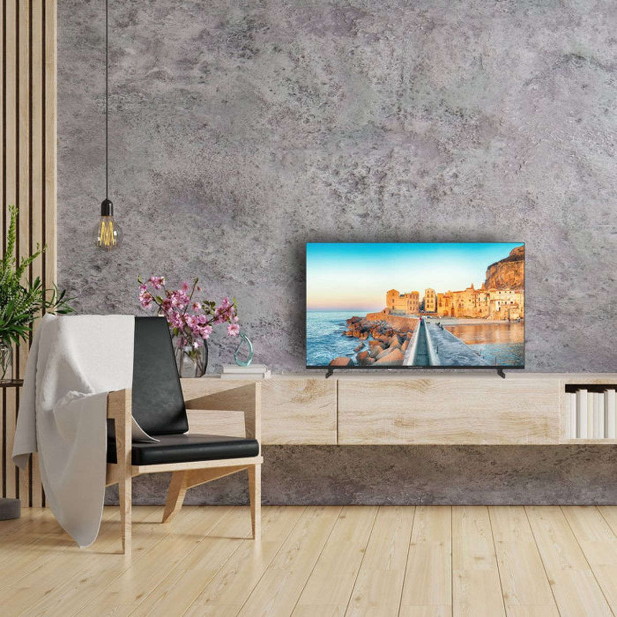 Una poltrona davanti a un mobile TV che mostra una città costiera sullo schermo.