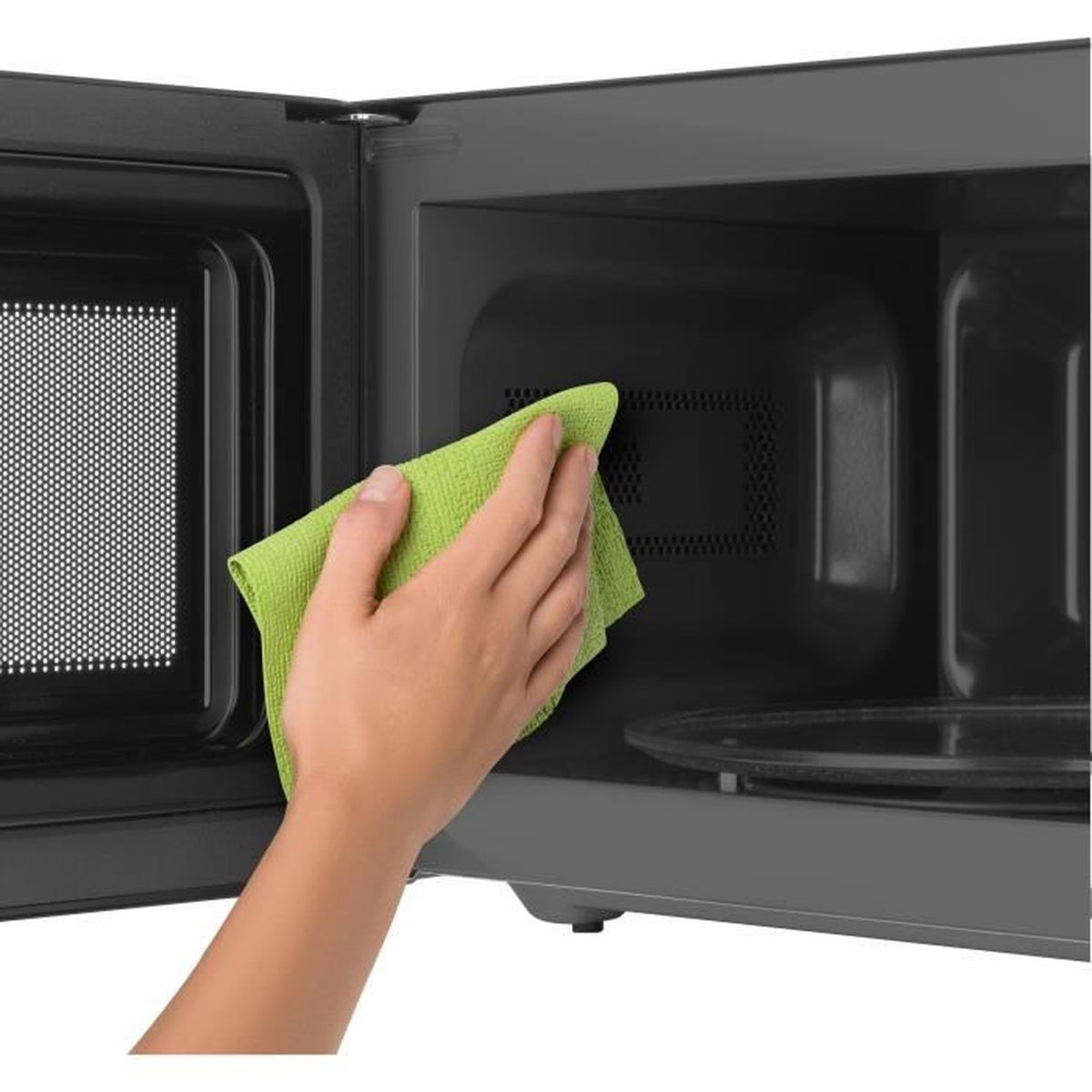 Una mano pulisce l'interno di un microonde con un panno verde.