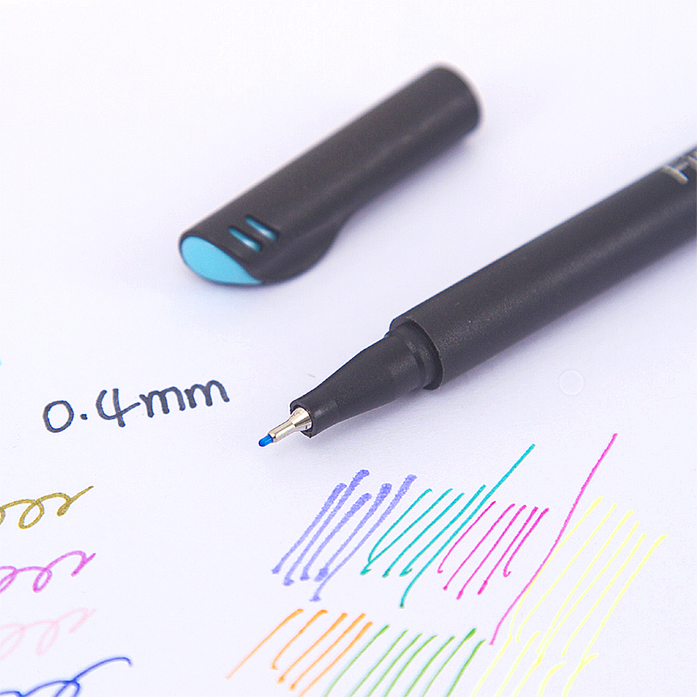 Una penna nera con punta blu giace accanto al suo cappuccio. Linee colorate sono disegnate sulla carta.