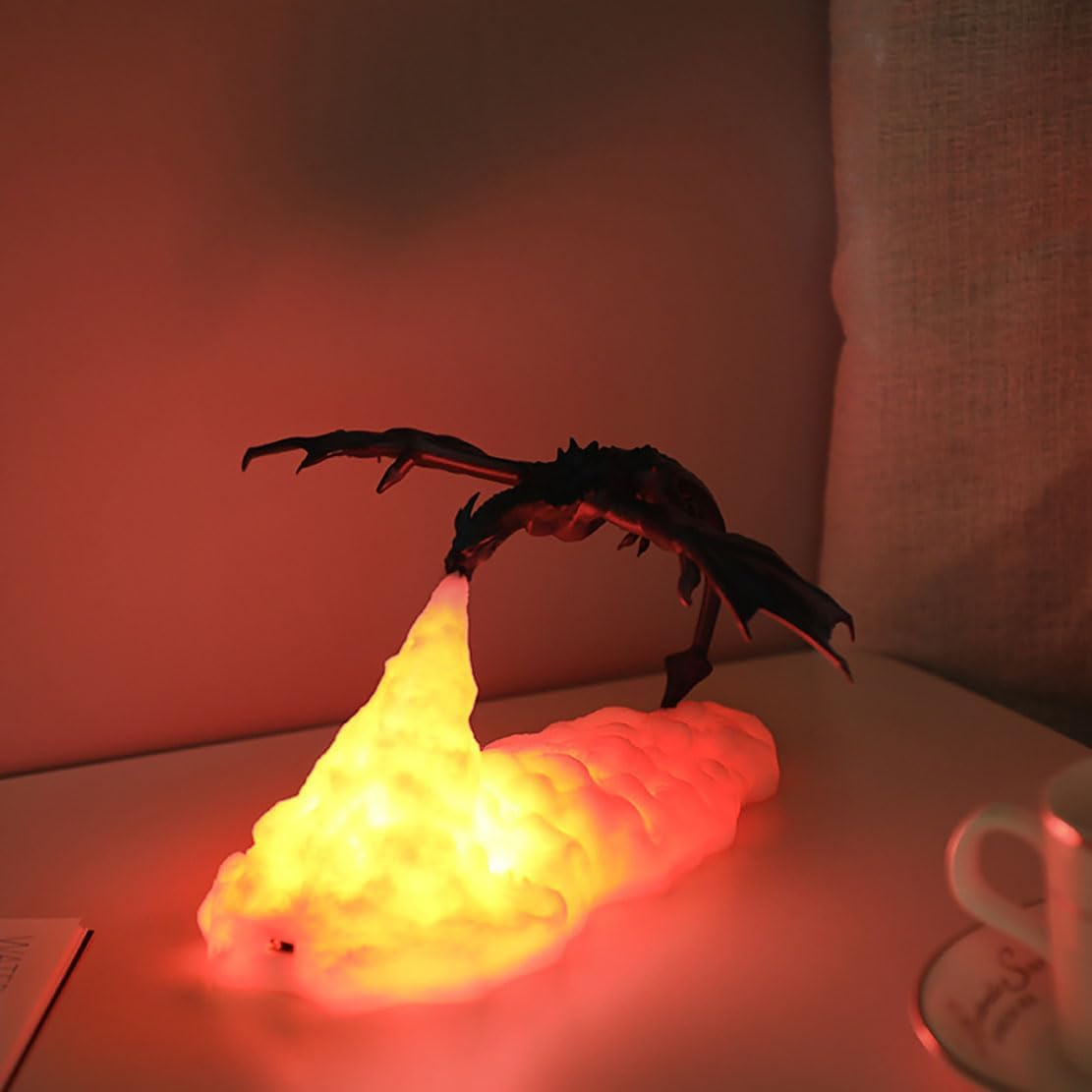 Eine schwarze Drachenfigur speit eine helle gelbe Flamme auf einen weißen wolkenartigen Sockel.