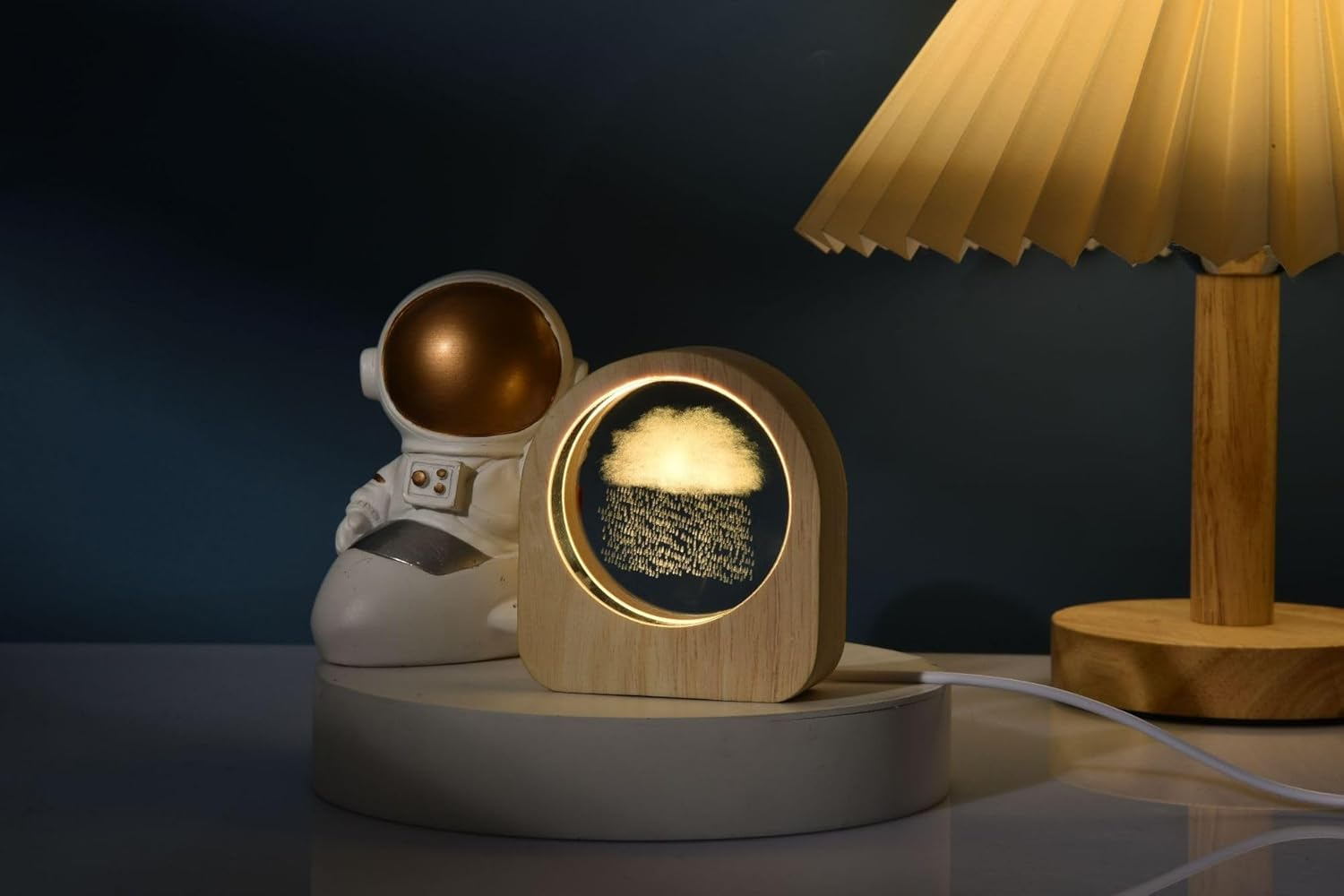 Astronautenfigur neben einer Holzlampe mit Wolken- und Regenmotiv.
