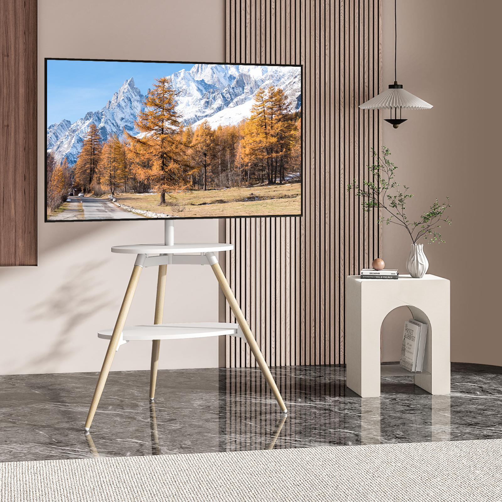 Ein moderner weißer TV-Ständer mit Holzbeinen trägt einen Fernseher mit Berglandschaft.