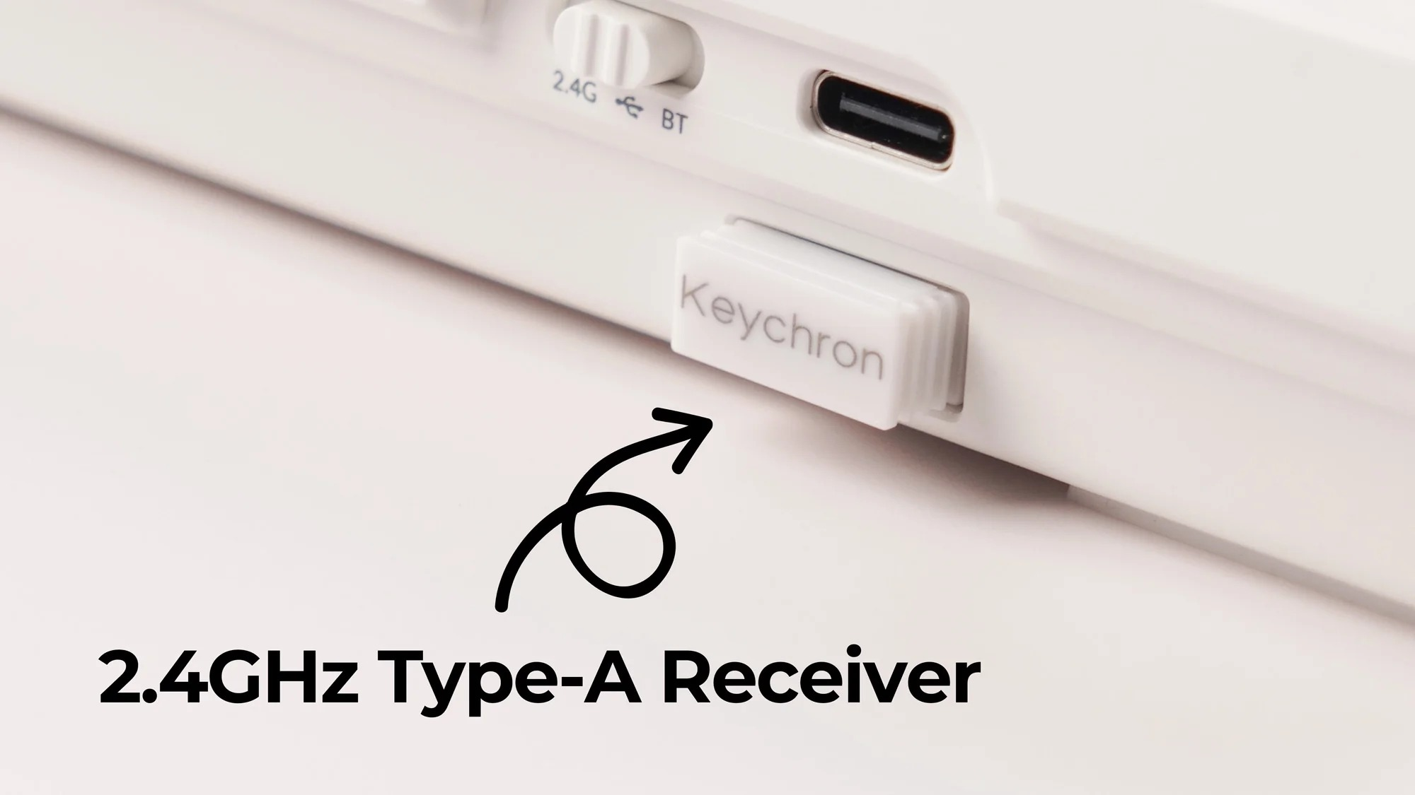 Białe urządzenie Keychron ze przełącznikiem 2.4G/BT, portem USB-C i gniazdem odbiornika.