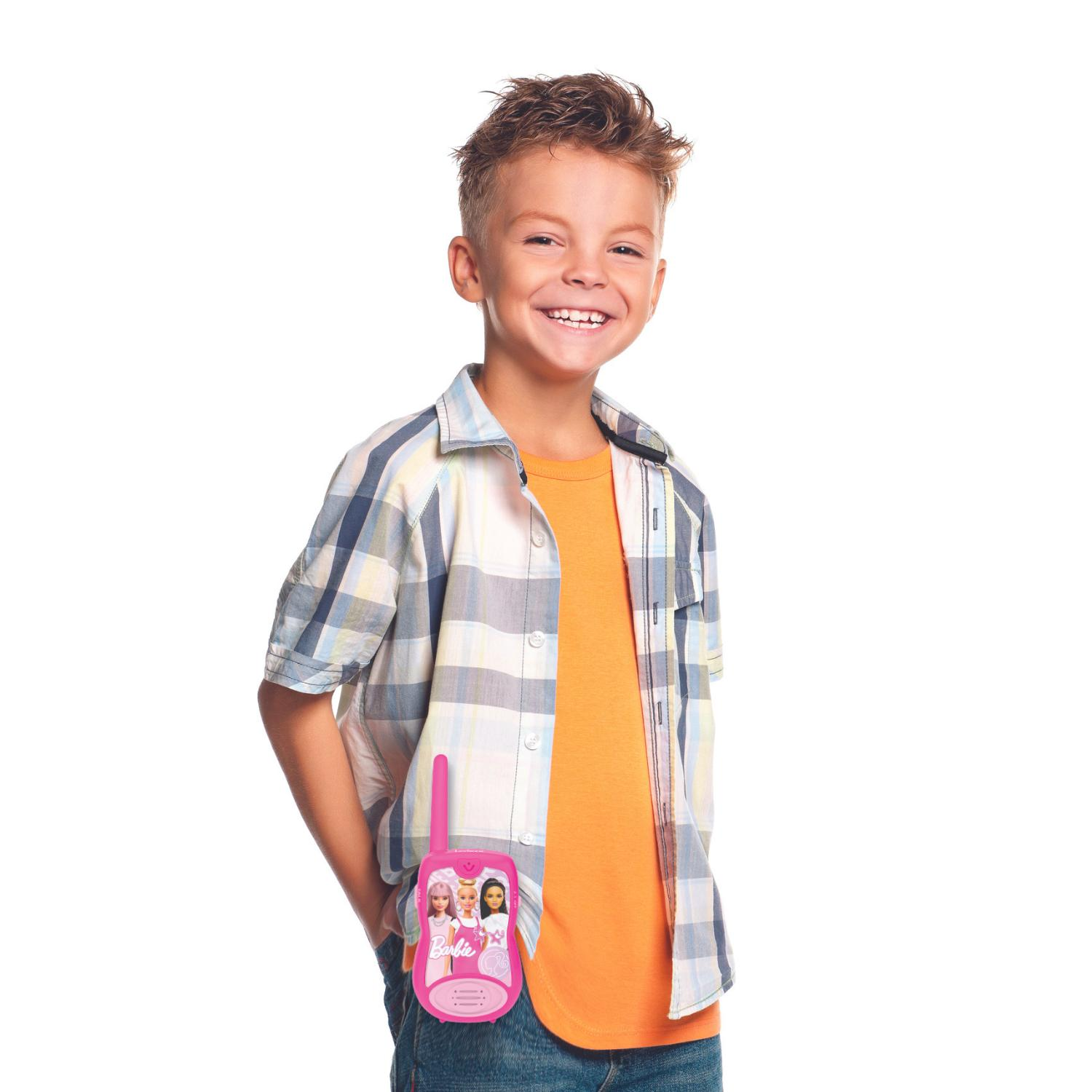 Ragazzo sorridente in camicia a quadri indossa walkie-talkie rosa Barbie.
