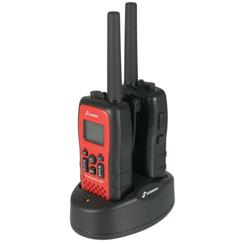 Due walkie-talkie rossi e neri in una base di ricarica nera.