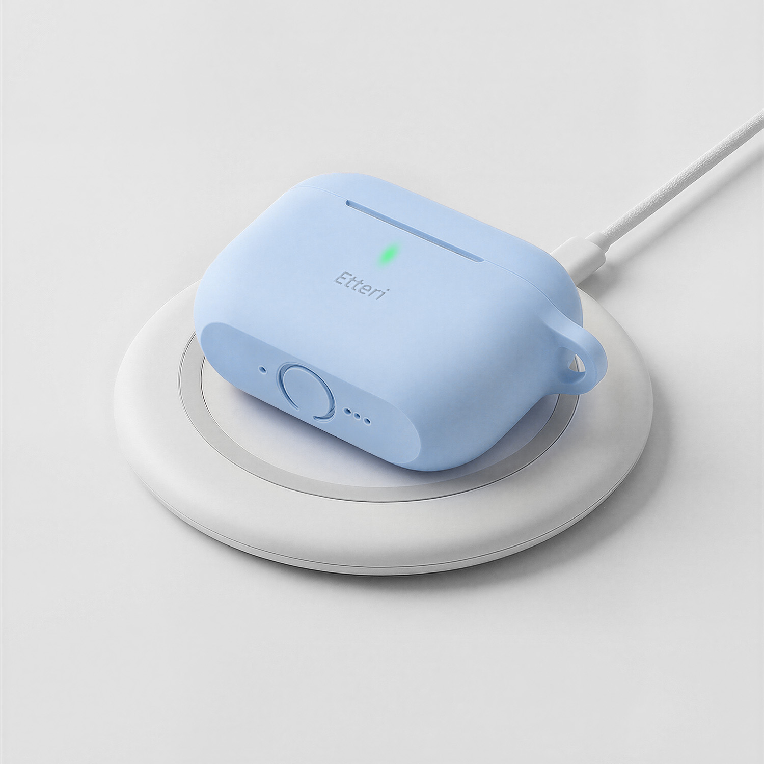 Una custodia blu per auricolari si carica wireless su una base bianca.
