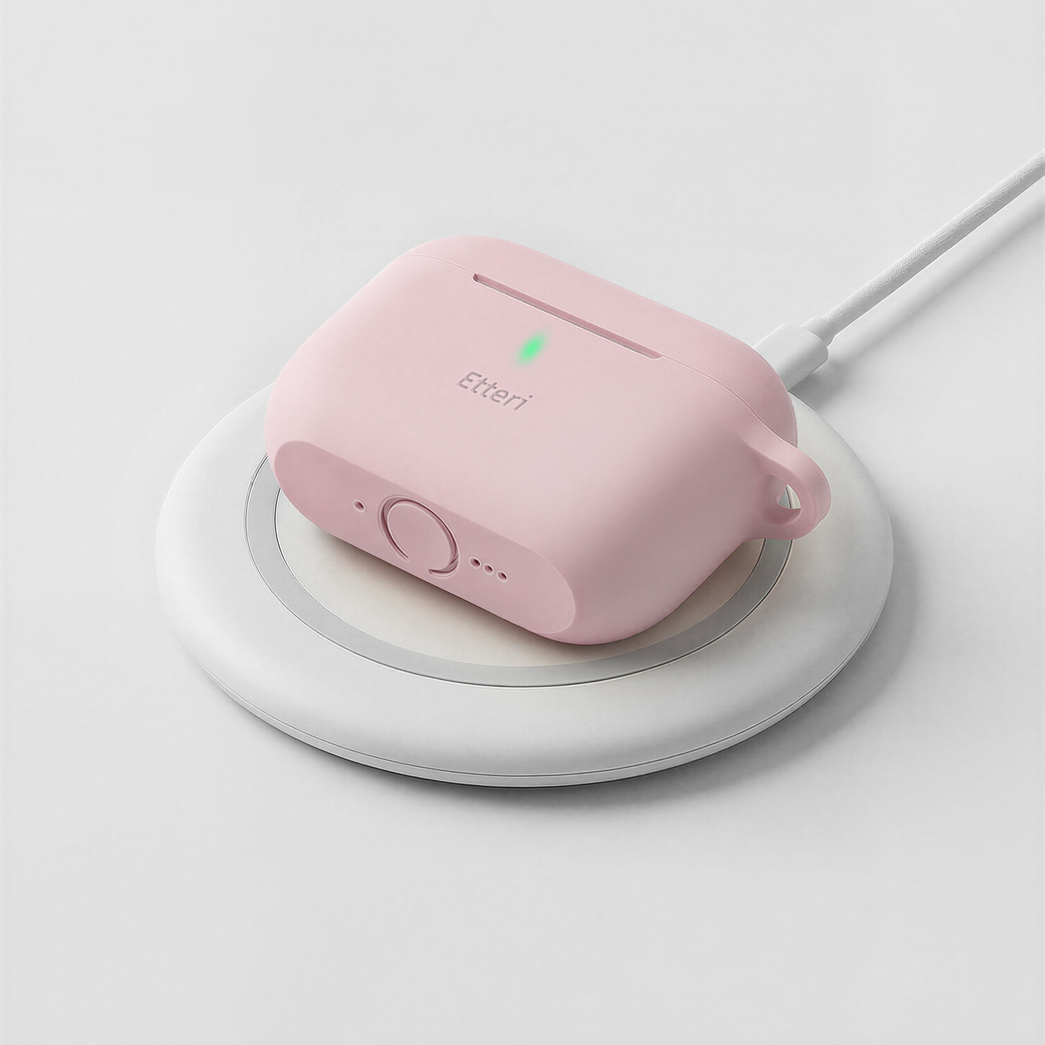 Una custodia di ricarica rosa poggia su una stazione di ricarica bianca con una spia verde.