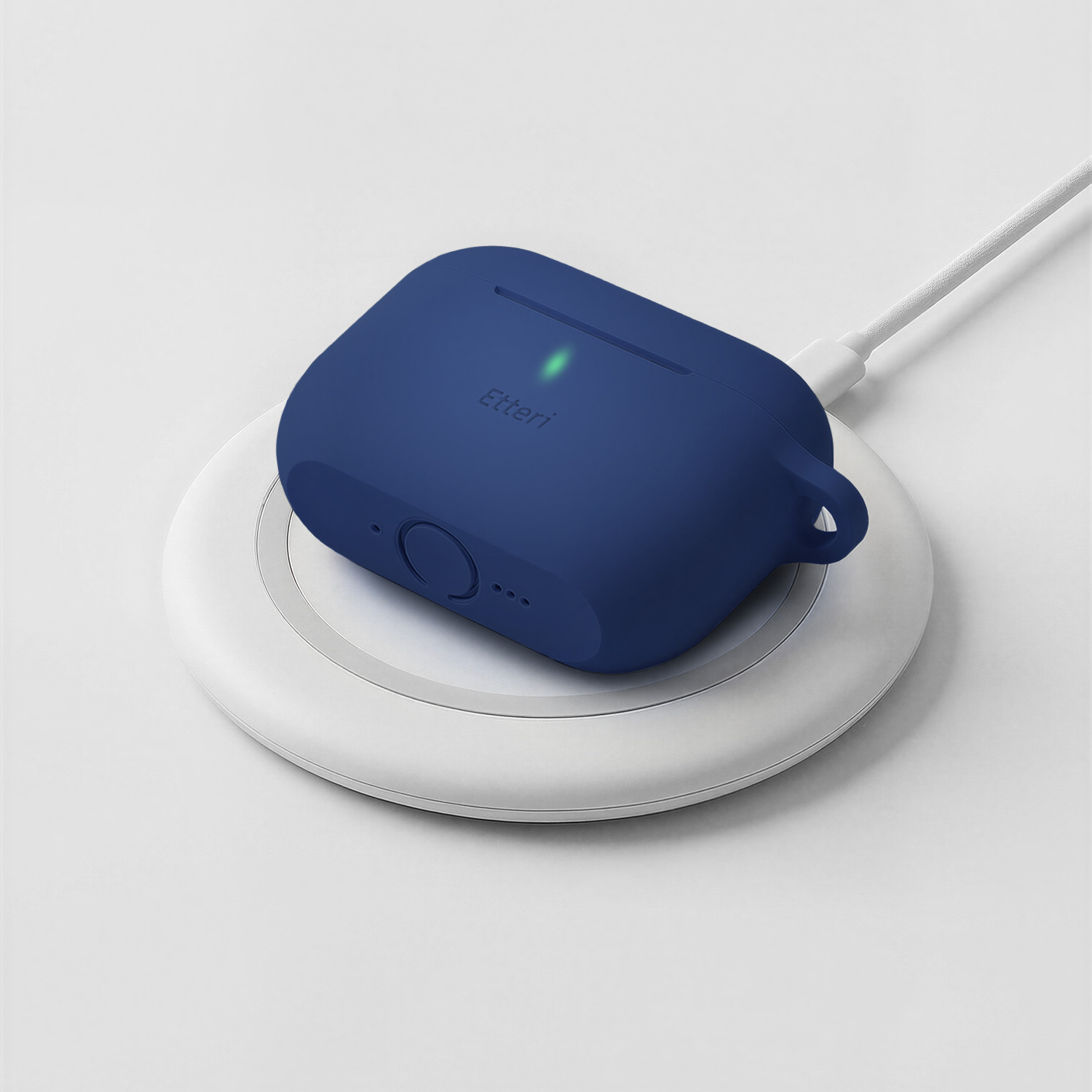 Una custodia blu per auricolari si sta caricando su un caricatore wireless bianco.