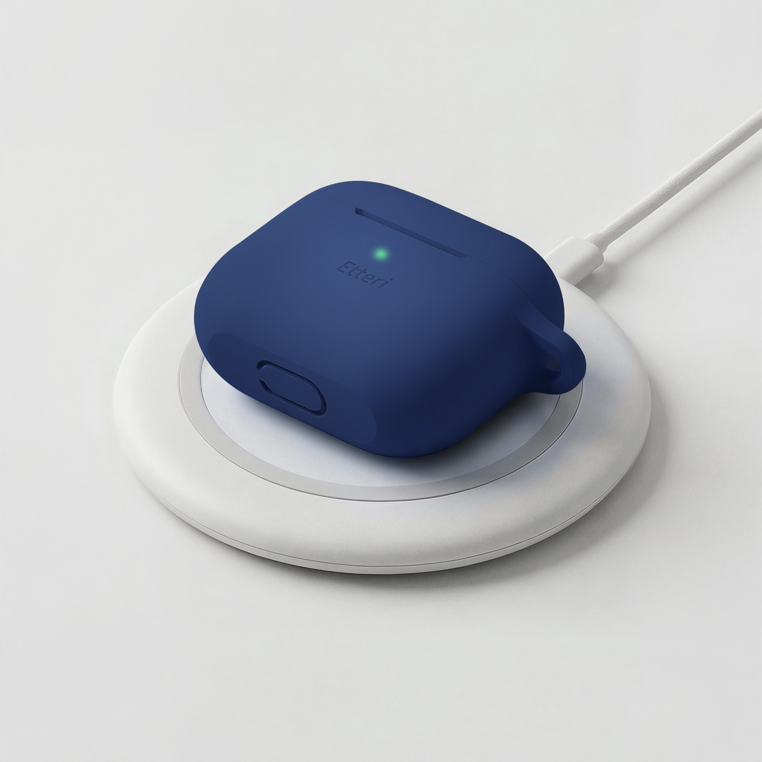 Una custodia blu scuro per auricolari wireless si ricarica su una base di ricarica bianca.