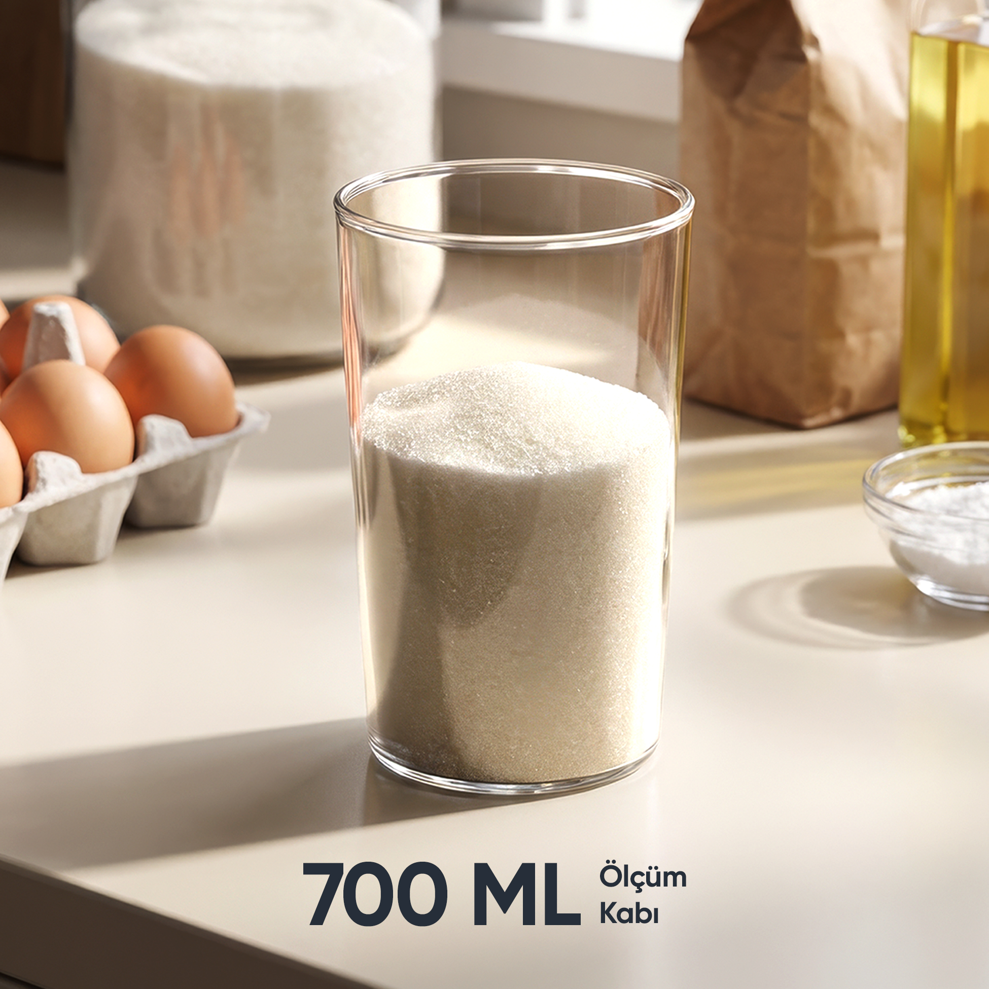 Yumurta, yağ ve un yanında şeker dolu bardak. 700 ml ölçüm kabı.
