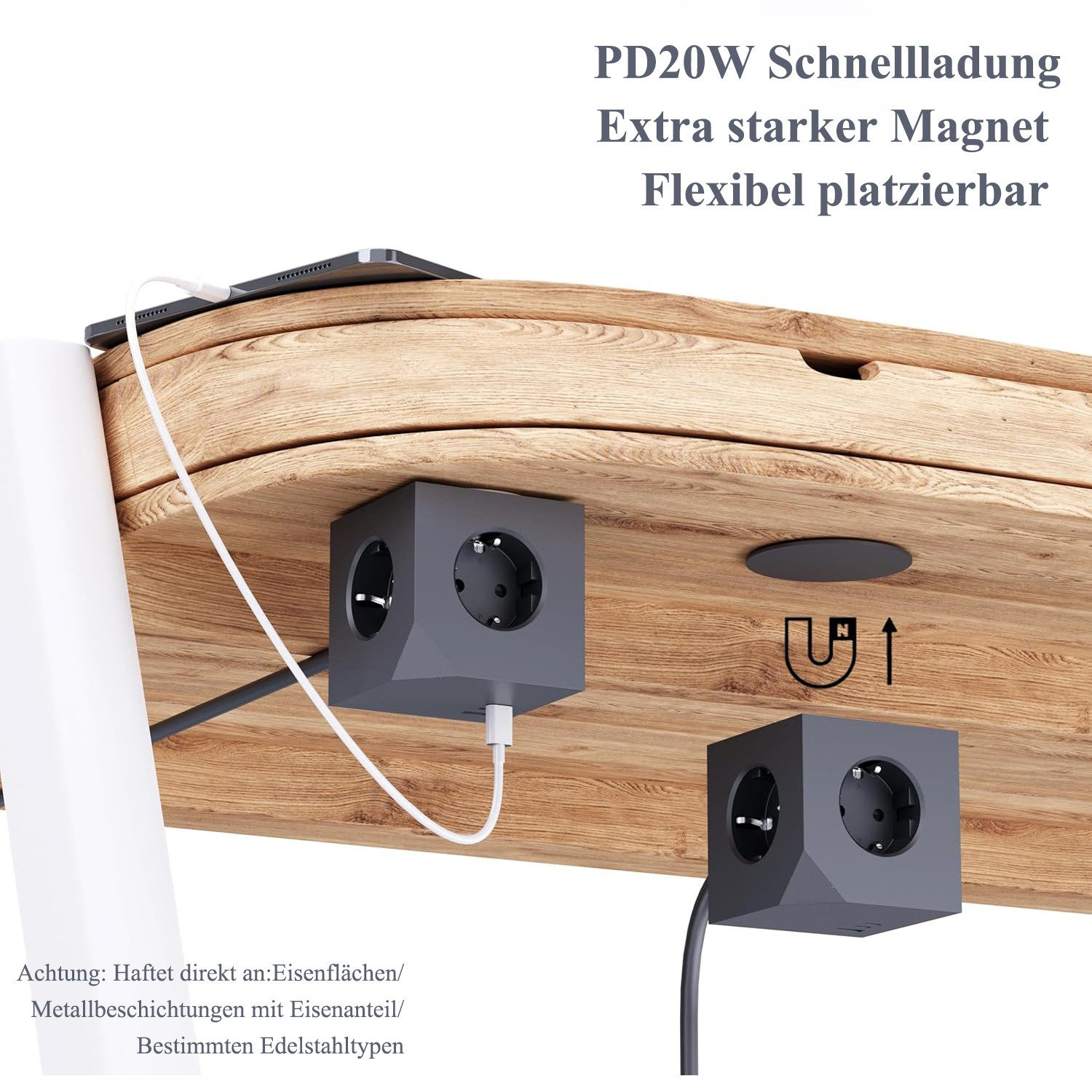 Graue Steckdosenwürfel an Holztisch, ein Tablet wird geladen.