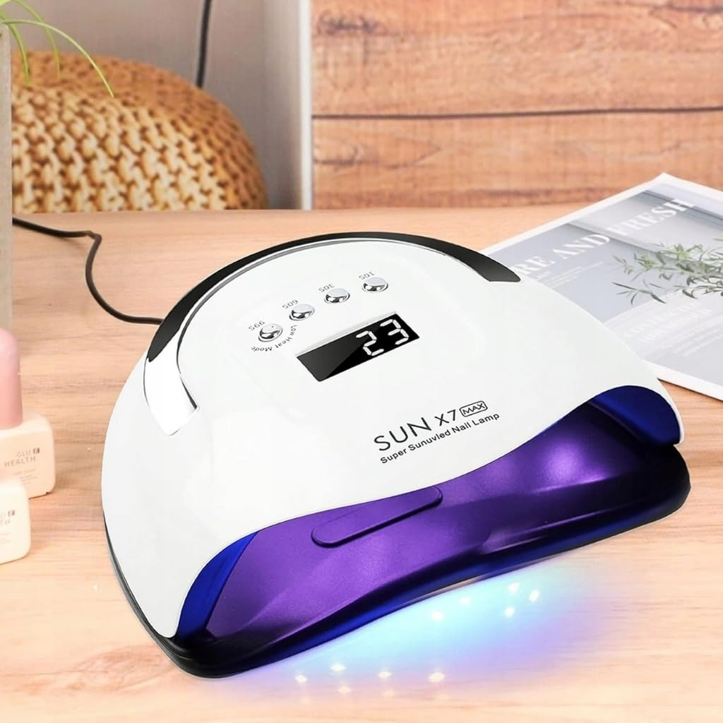 Ein weißer UV-Nagellampen-Trockner mit violetter Basis und digitaler Anzeige steht auf einem Holztisch.