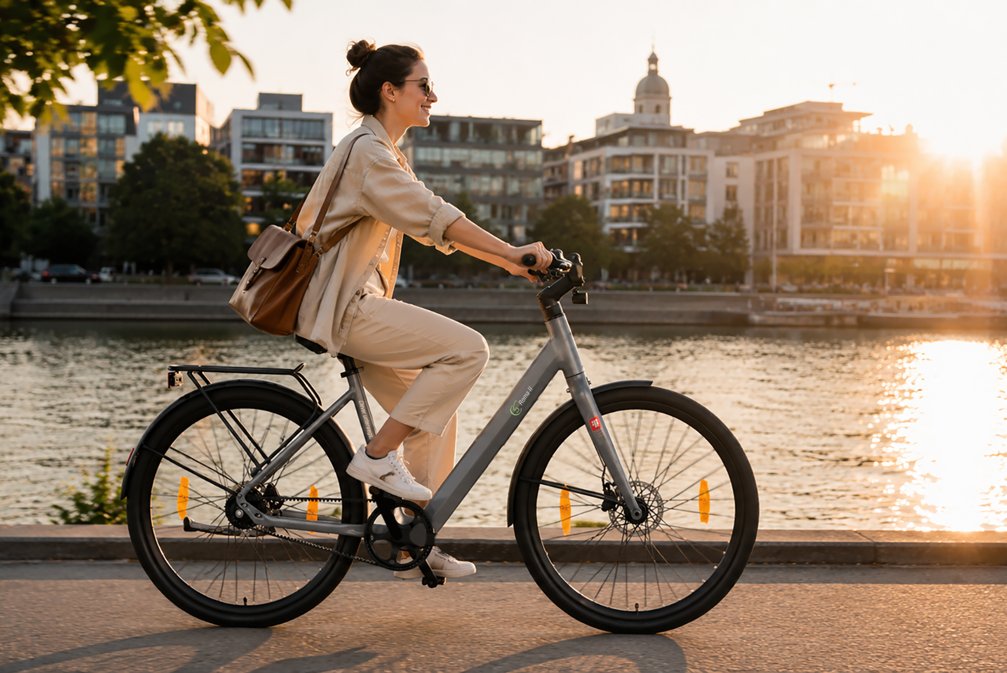 Eine Frau fährt mit einem Fahrrad am Wasser entlang, im Hintergrund Gebäude bei Sonnenuntergang.