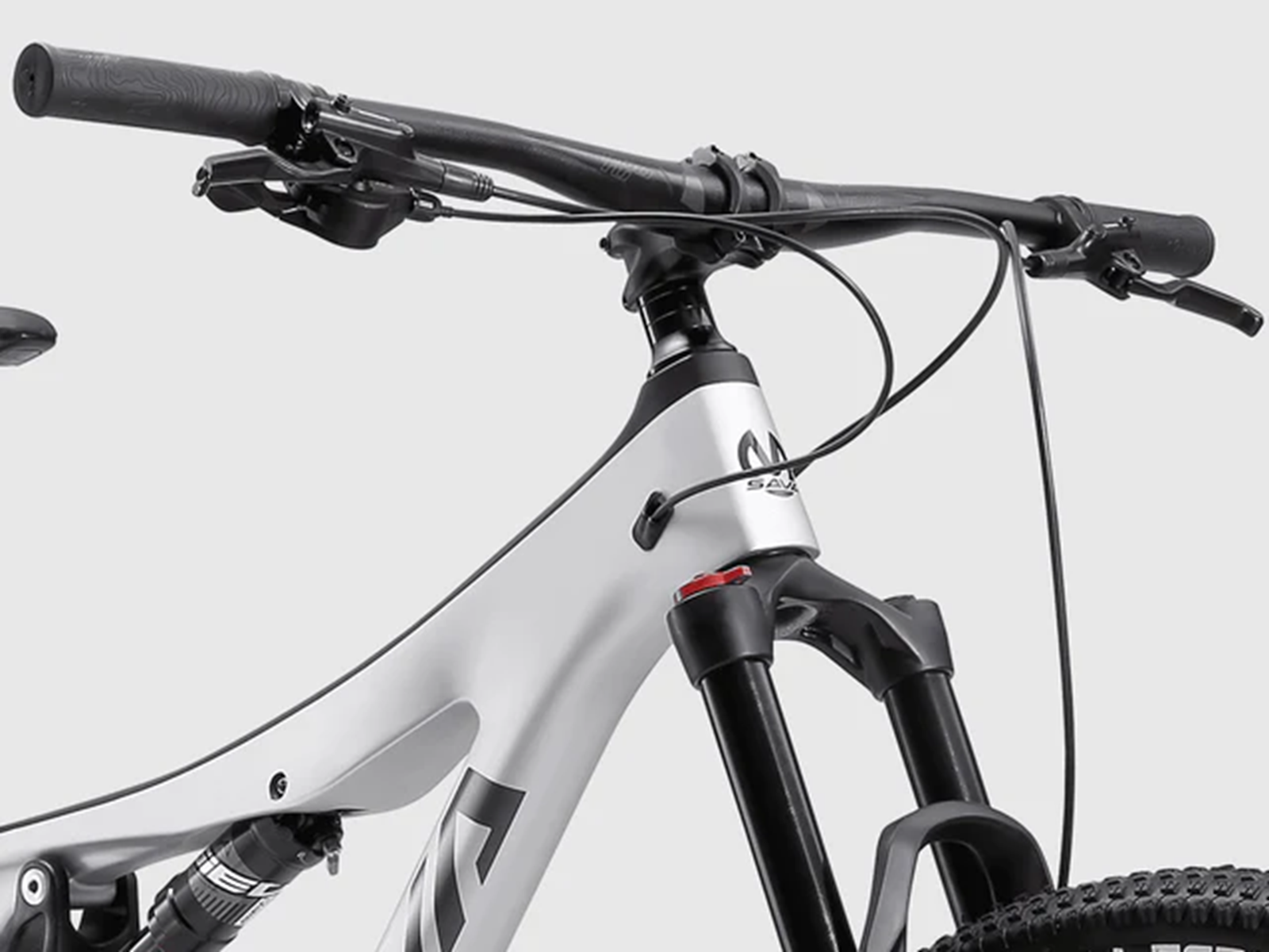 Nahaufnahme des Lenkers, der Vordergabel und eines Teils des Rahmens eines weißen Mountainbikes.