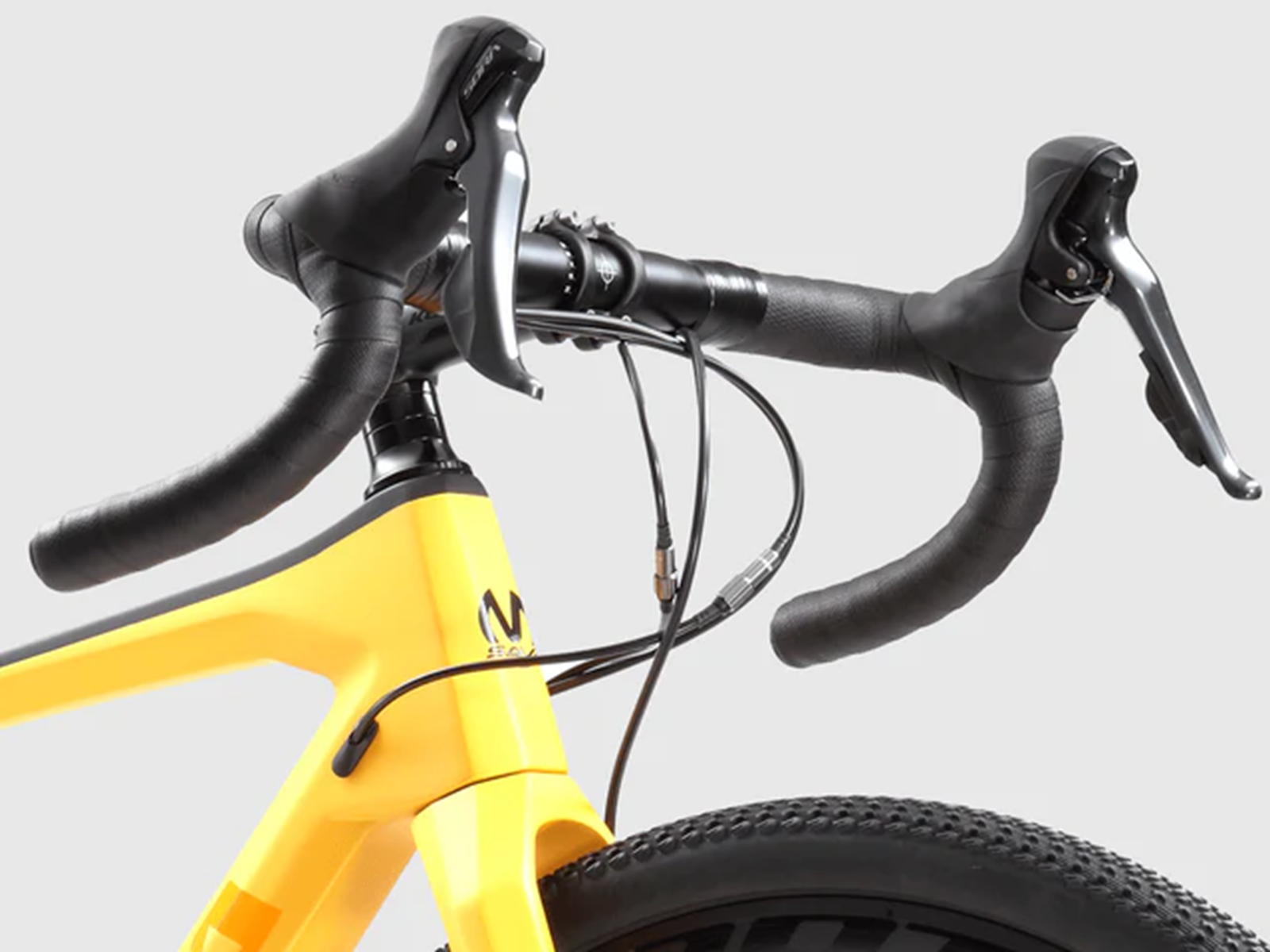 Gelbe Fahrradgabel mit schwarzen Lenkern und Bremshebeln. Vorderrad sichtbar.
