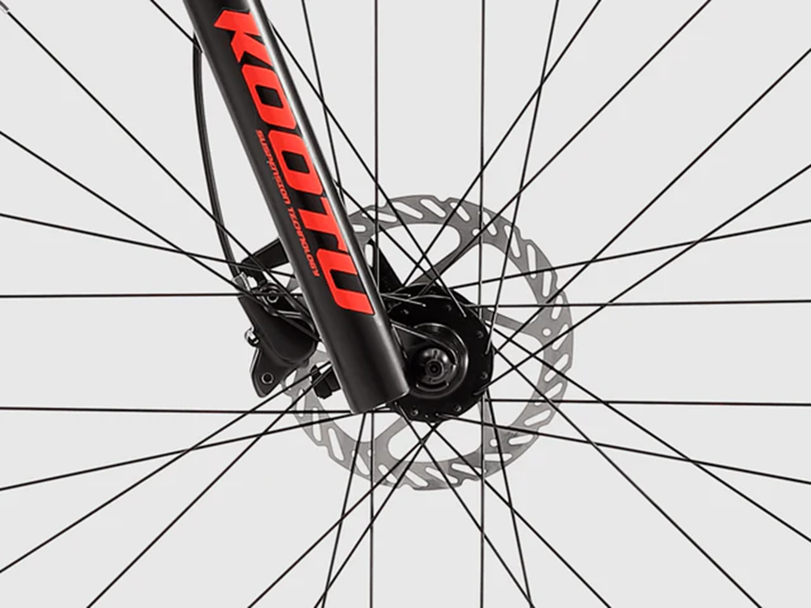 Nahaufnahme einer Fahrradgabel mit roten Schriftzügen und Scheibenbremse.