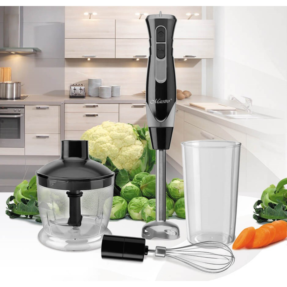 Frullatore a immersione con accessori, verdure e bicchiere in cucina.