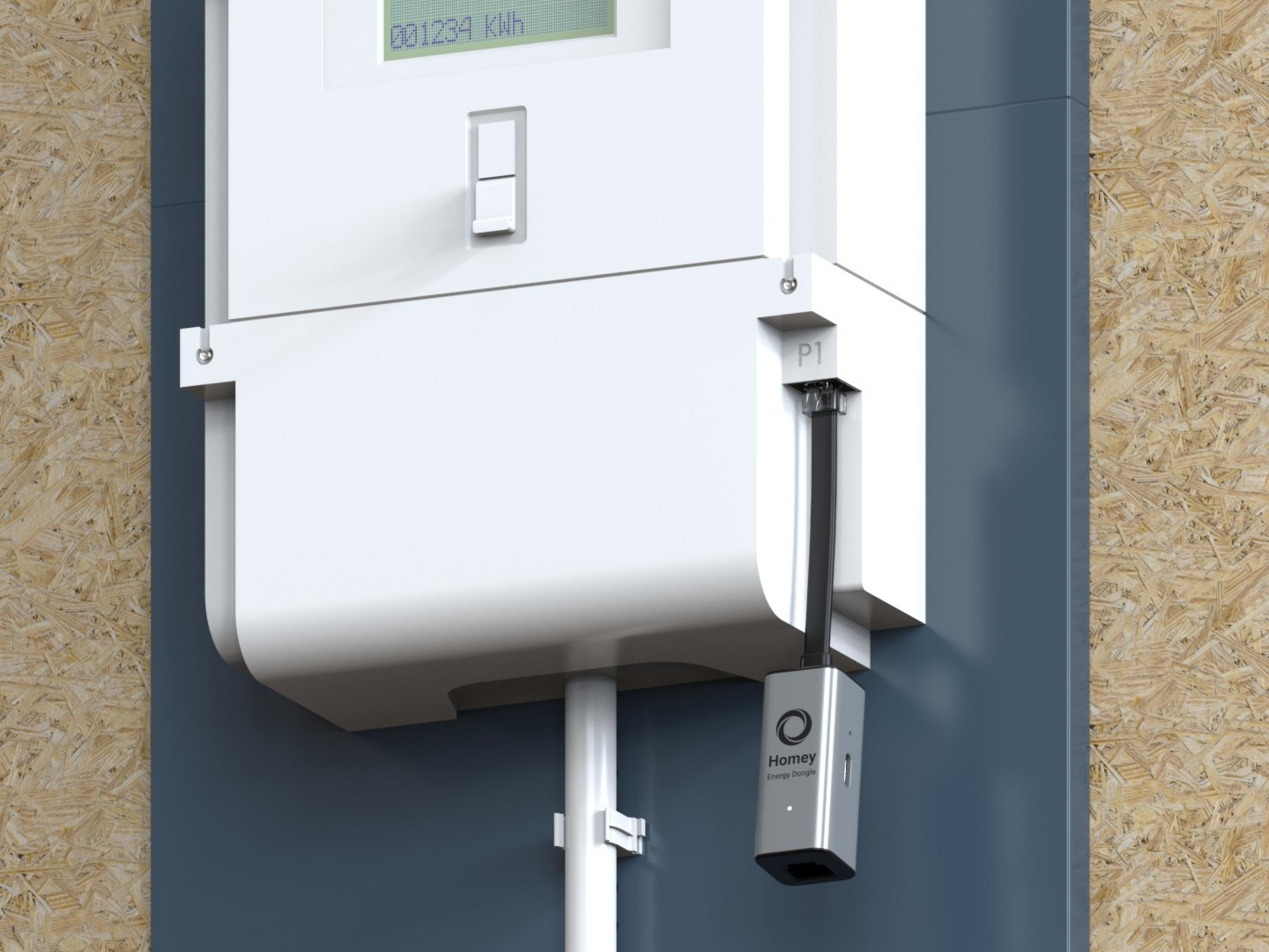 Ein weißer Stromzähler mit einem grauen Homey Energy Dongle, an der Wand montiert.
