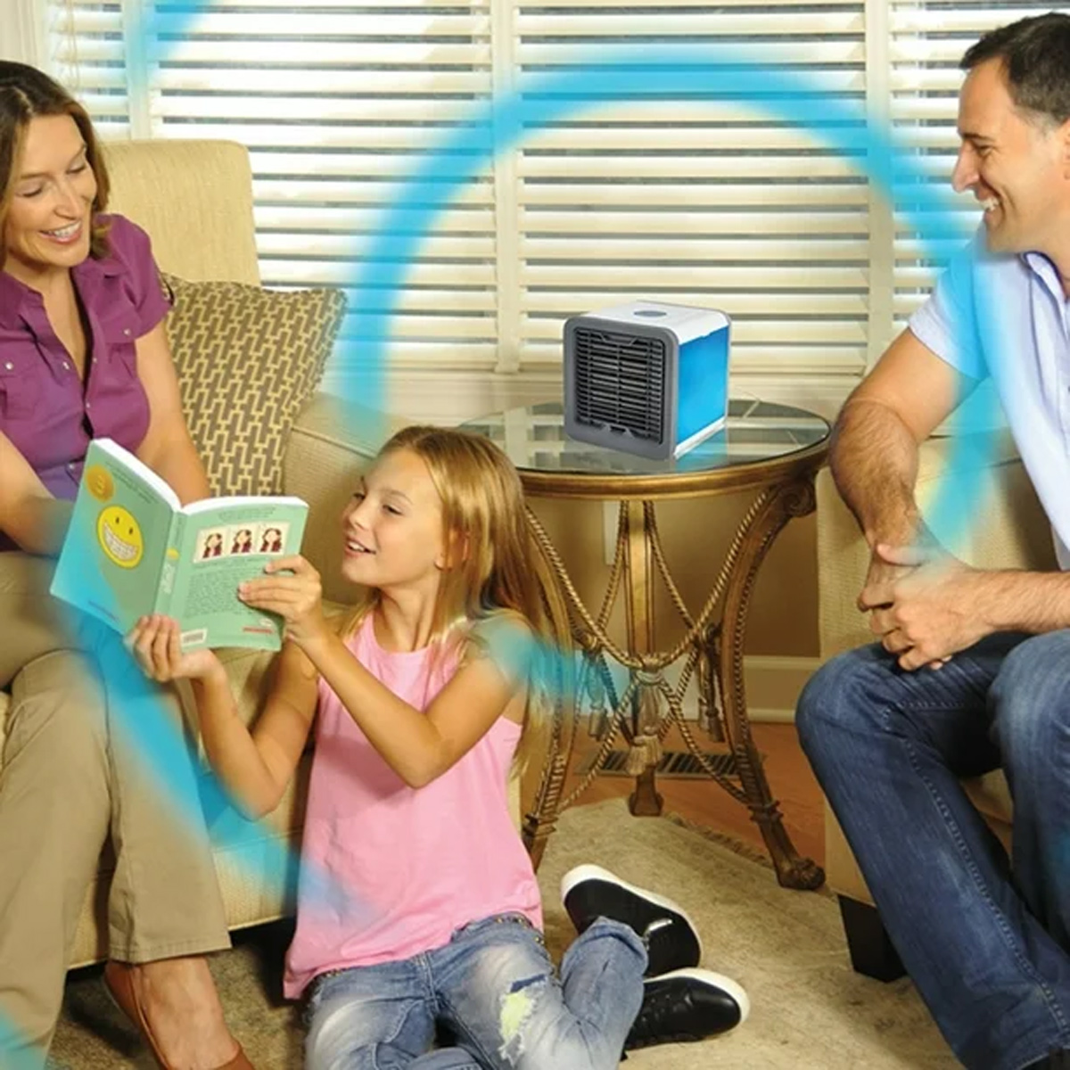 Familie genießt kühle Luft von einem tragbaren Gerät in einem Wohnzimmer.