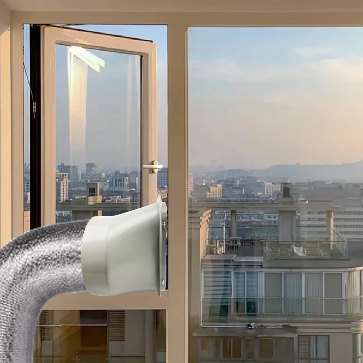 Ein flexibler silberner Schlauch mit einem weißen Auslass ragt in ein Fenster hinein. Stadtblick.