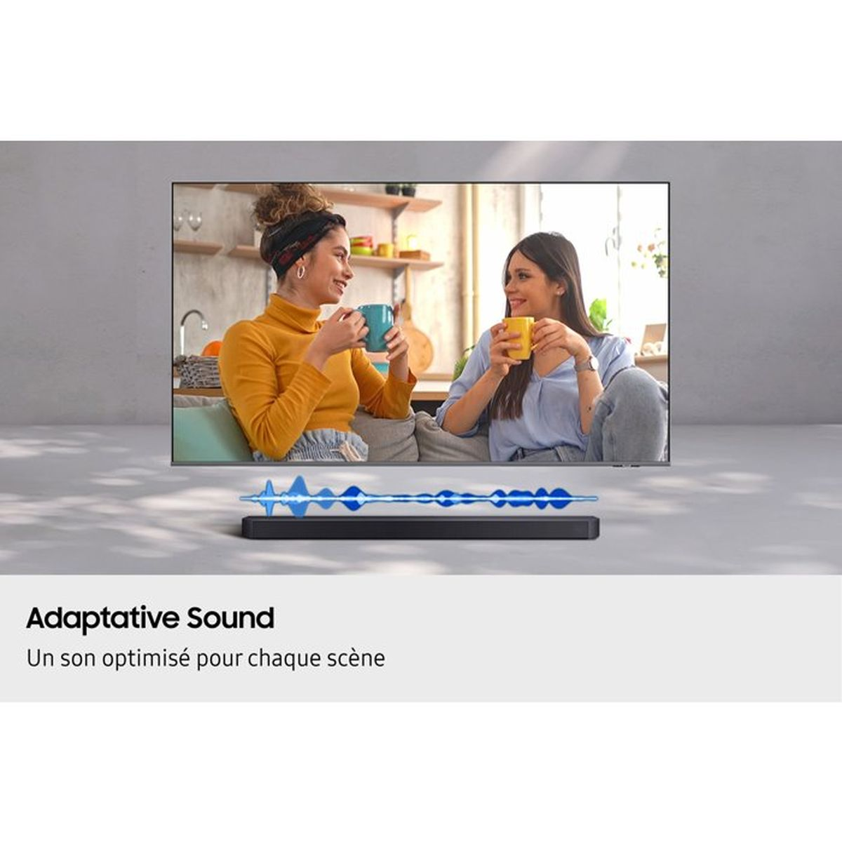 Zwei Frauen trinken aus Tassen vor einem Fernseher mit einer Soundbar darunter.