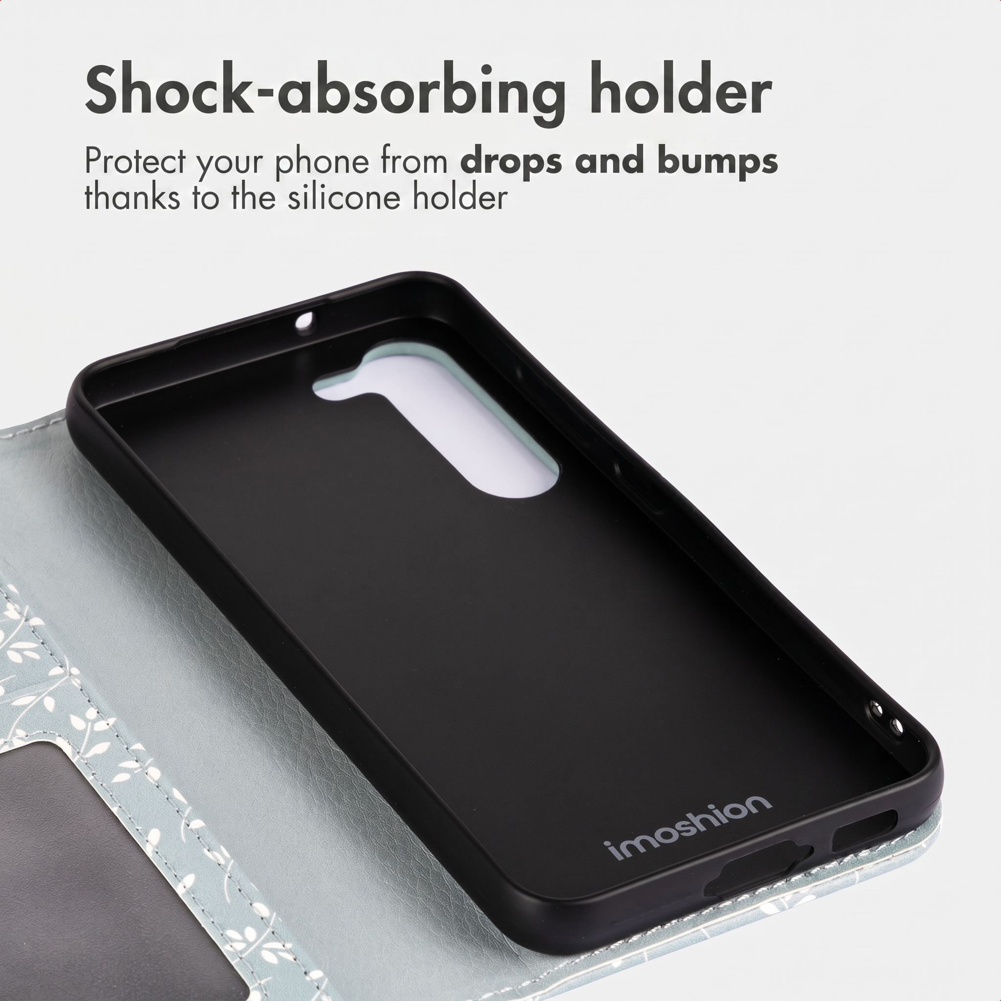 Custodia in silicone nera con logo Imoshion, su un portafoglio azzurro a fantasia floreale.