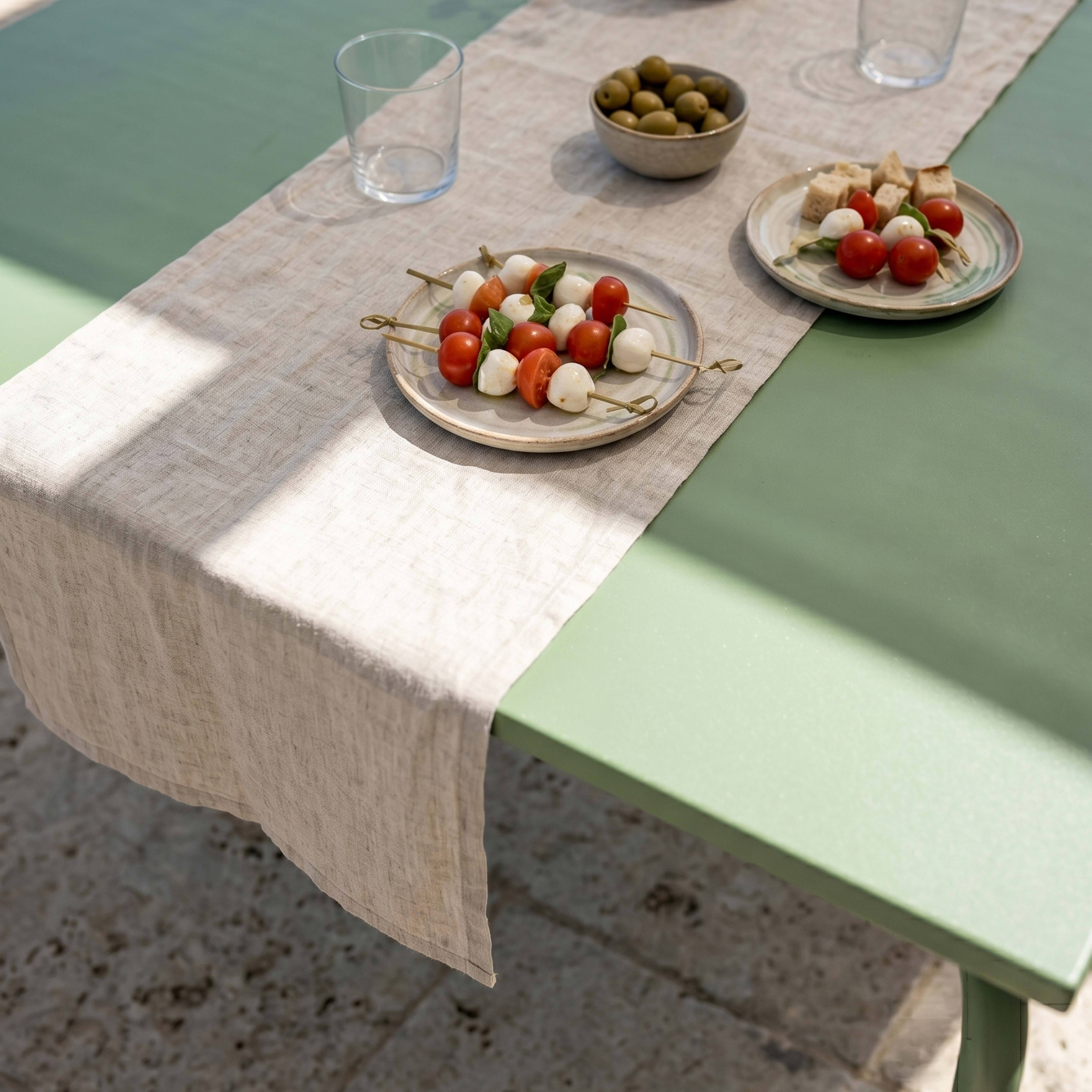 Caprese-Spieße mit Tomaten, Mozzarella und Basilikum auf einem Tisch.