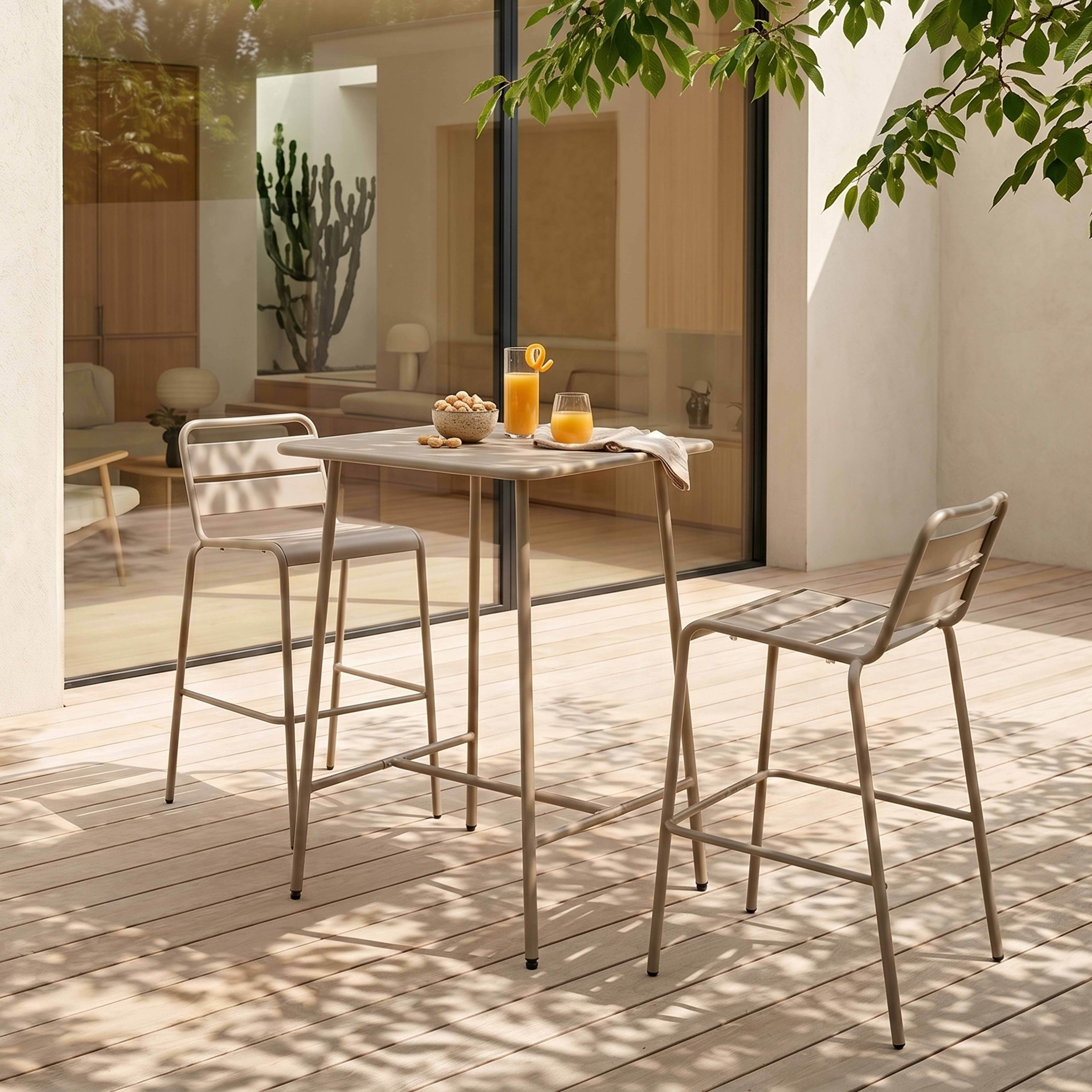 Ein heller Gartentisch mit zwei Hocker und zwei Gläsern Saft.