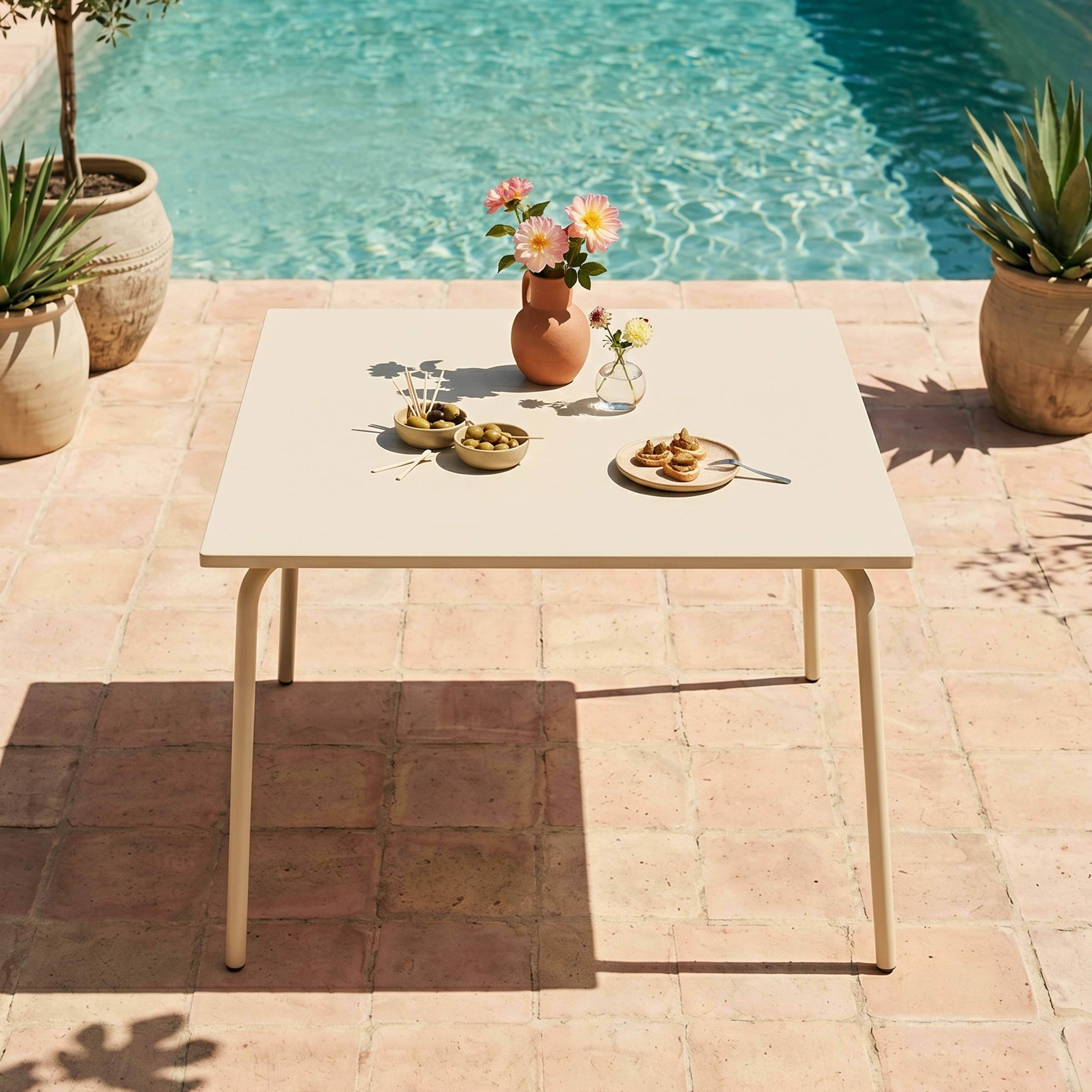 Ein Tisch mit Snacks und Blumen neben einem Pool mit Terranen Boden.