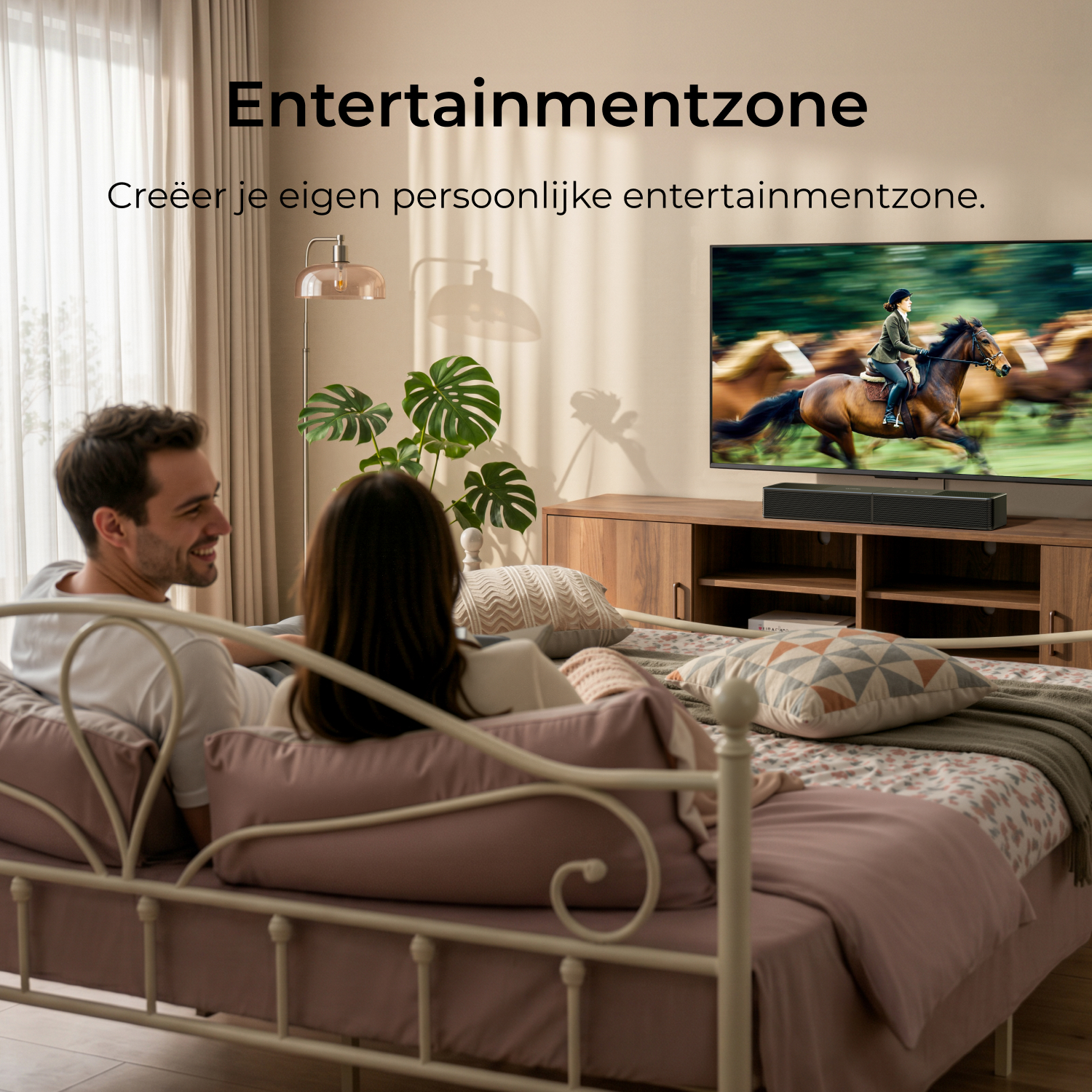 Un couple se détend sur un lit, regarde la télé. La télé montre une course de chevaux.