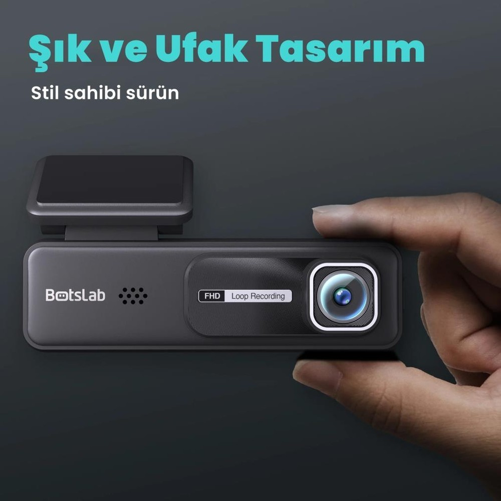 Bir el, FHD döngü kayıt özellikli küçük, siyah bir araç kamerası tutuyor.