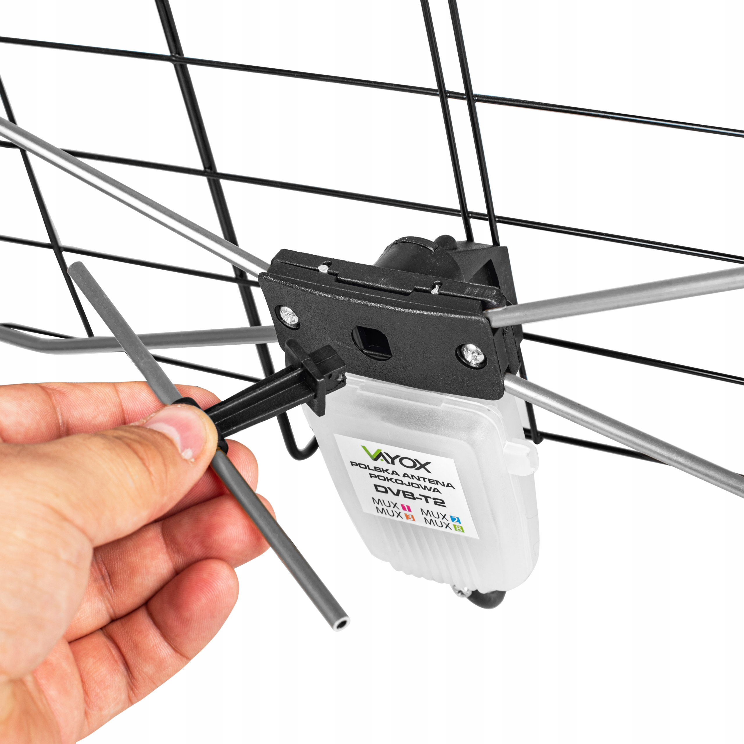 Eine Hand montiert eine schwarze Antenne mit silbernen Elementen und einem weißen Kasten.