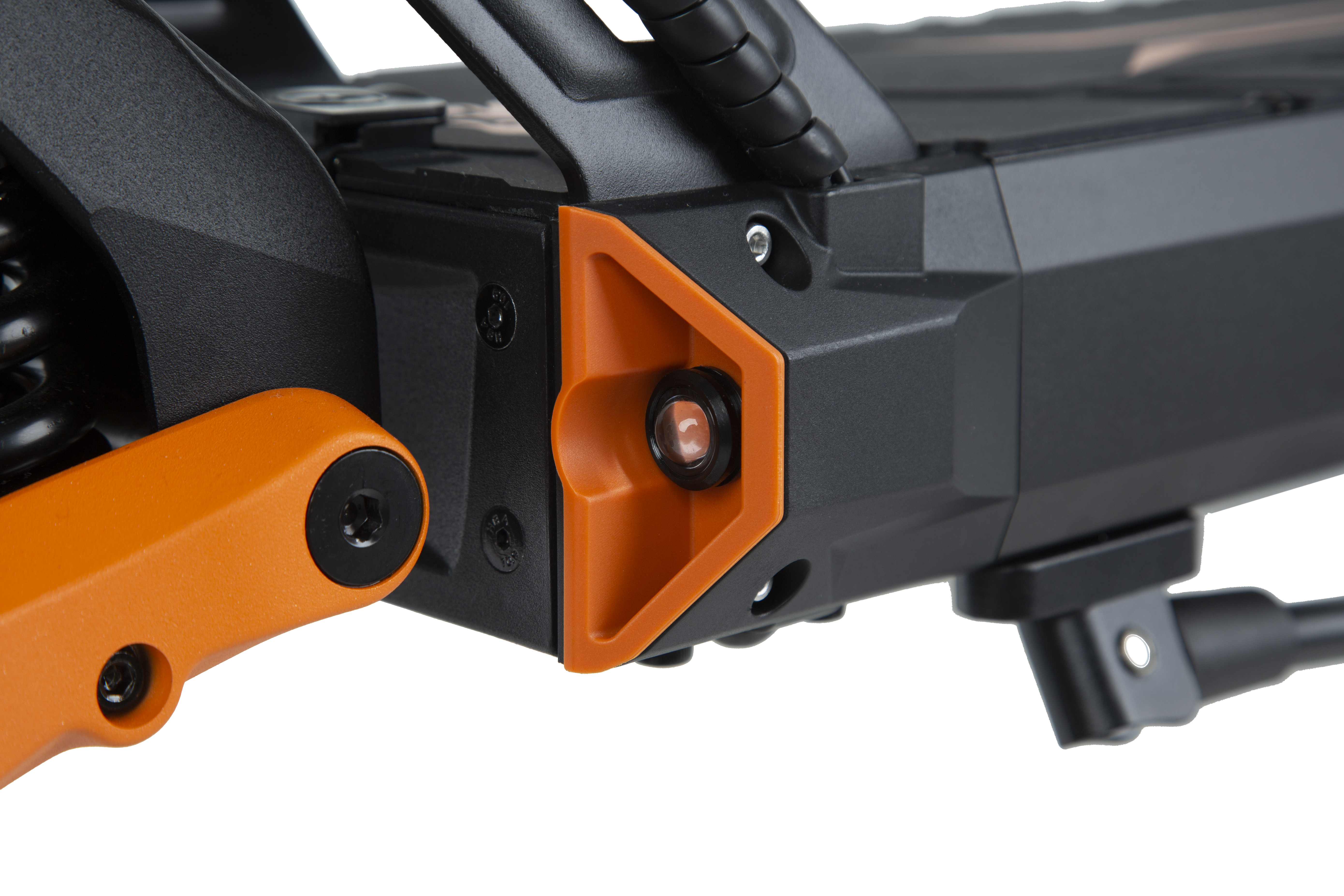Primer plano de un patinete eléctrico negro y naranja mostrado de lado.