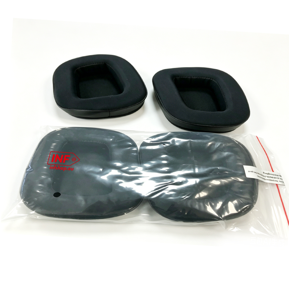Zwei schwarze Ohrpolster auf weißem Untergrund, zwei in Plastiktüte.
