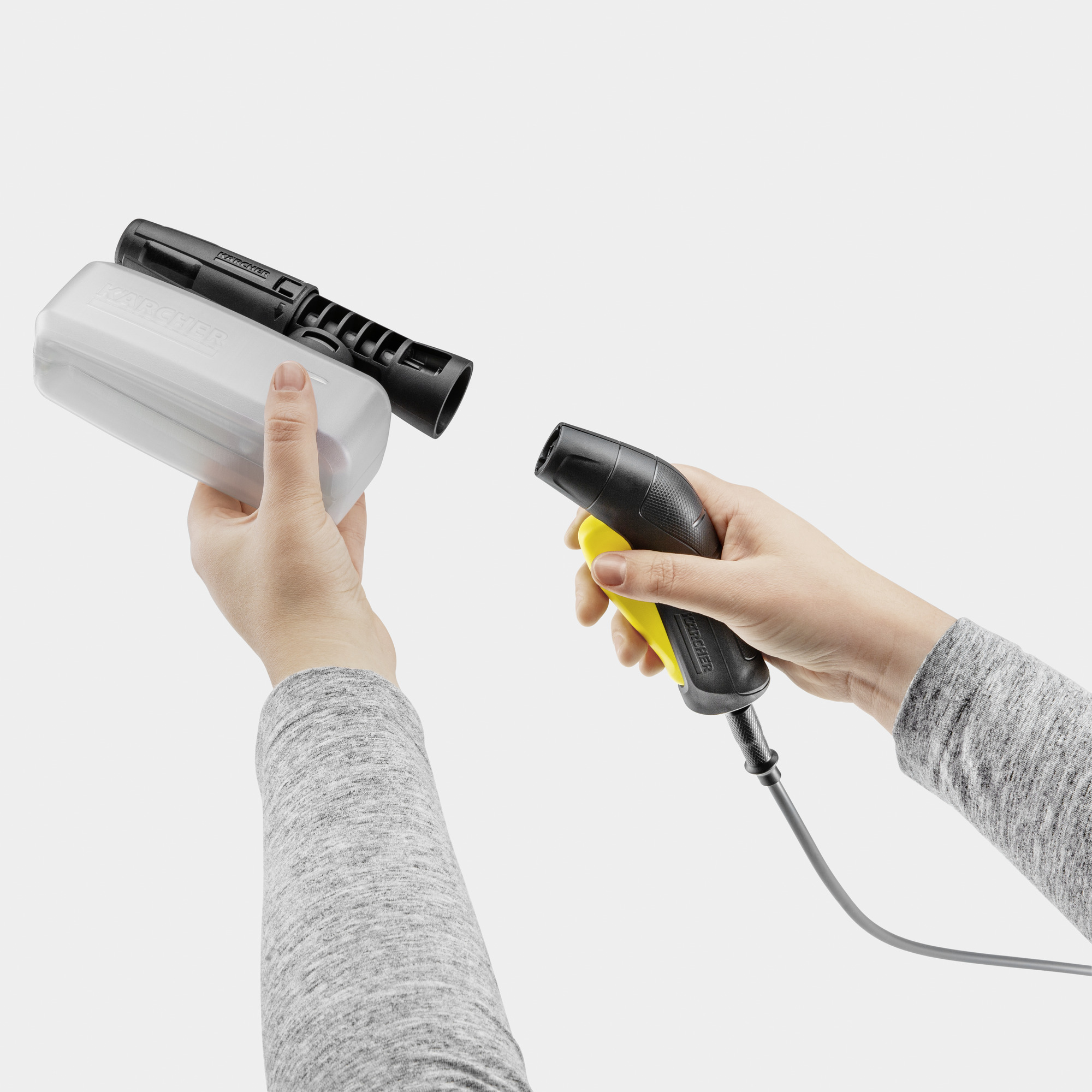 Mani tengono dispositivi Karcher: una bottiglia spray e una pistola.