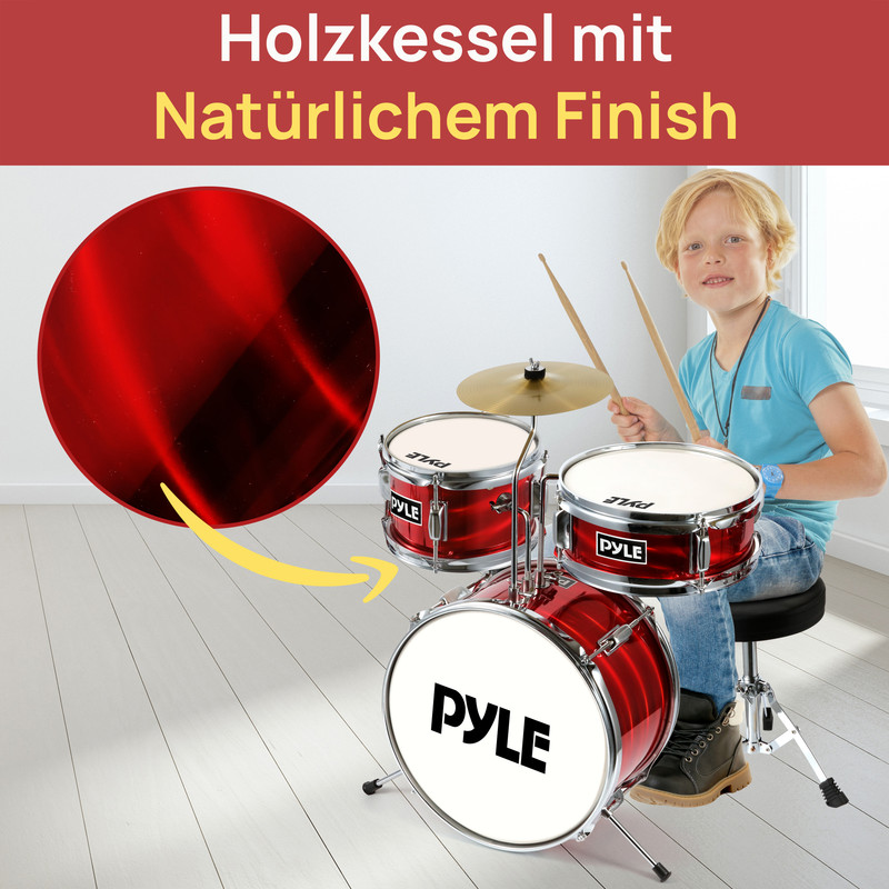 Junge spielt auf roter Kinder-Schlagzeug. Großer roter Kreis links daneben.