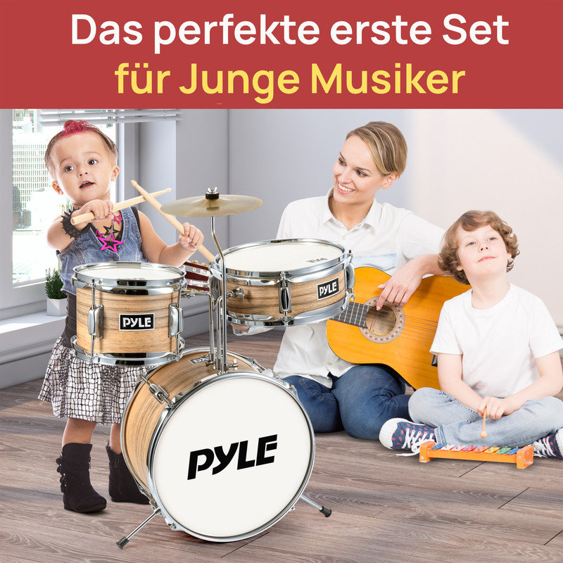Eine Frau spielt Gitarre mit Kindern, die Schlagzeug und Xylophon spielen.