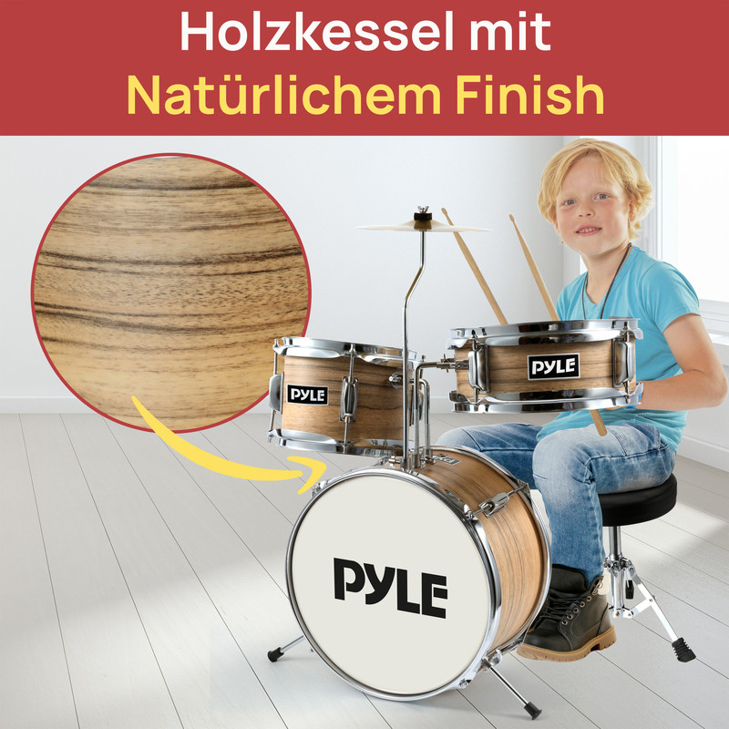 Junge sitzt an einem Schlagzeug mit Holzfurnier und hält Drumsticks.