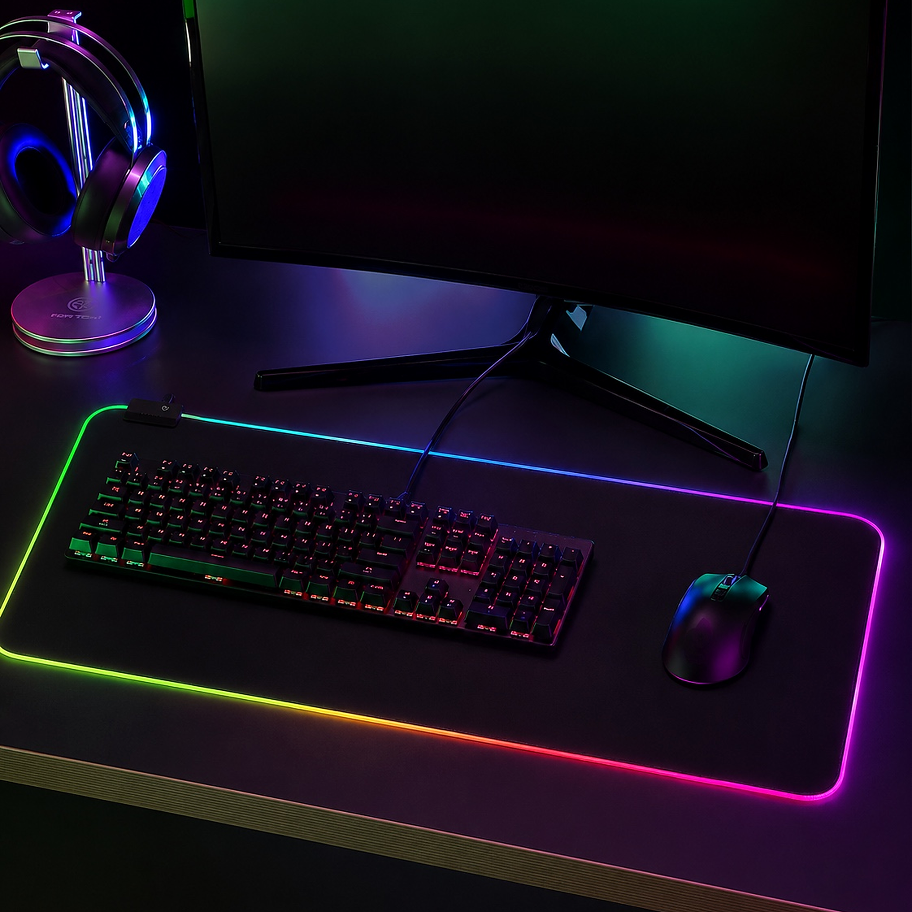 Ein Schreibtisch mit Tastatur, Maus, Kopfhörern und Monitor, beleuchtet von RGB-Licht.