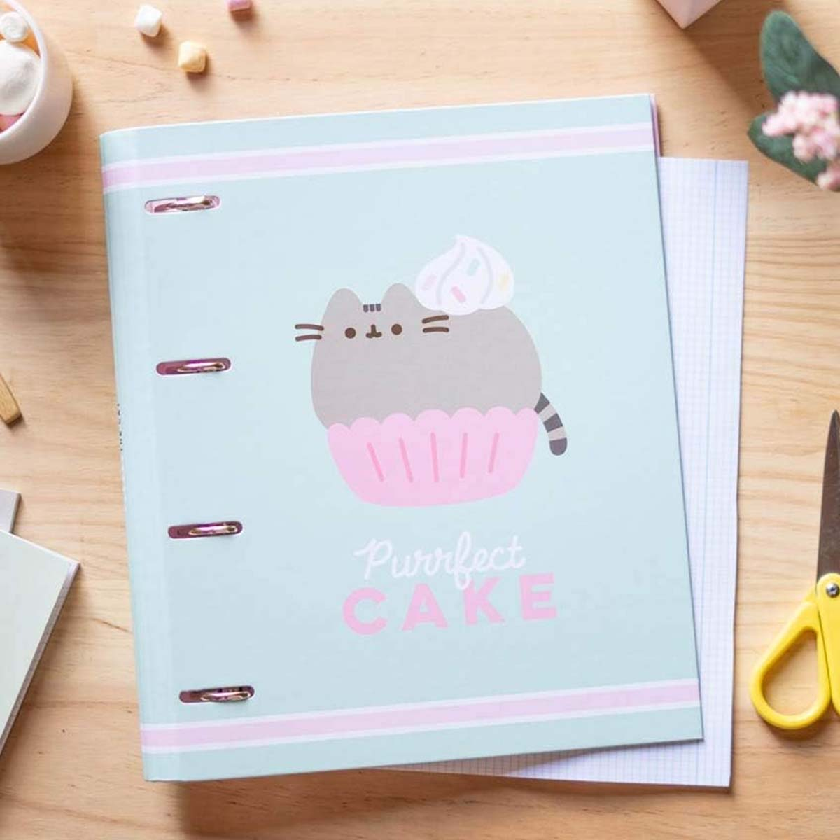 Ein hellblauer Ordner mit einem Cartoon-Katzen-Cupcake-Design und der Aufschrift „Purrfect CAKE“.