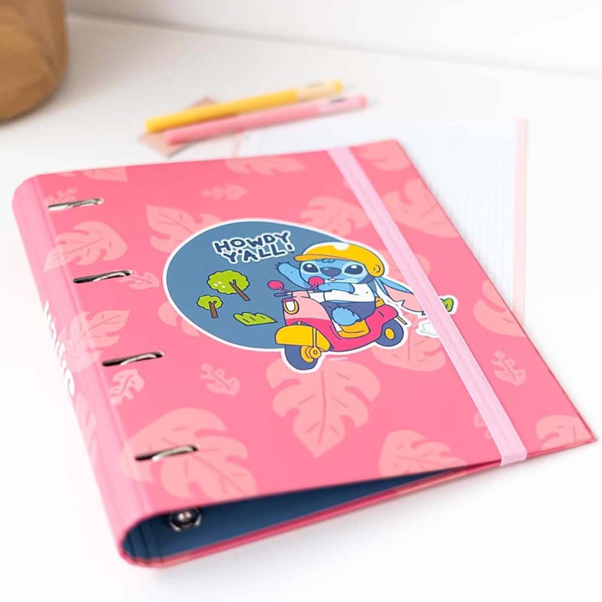 Ein pinker Ordner mit Blattmuster und Stitch auf einem Roller. Text: HOWDY Y'ALL!